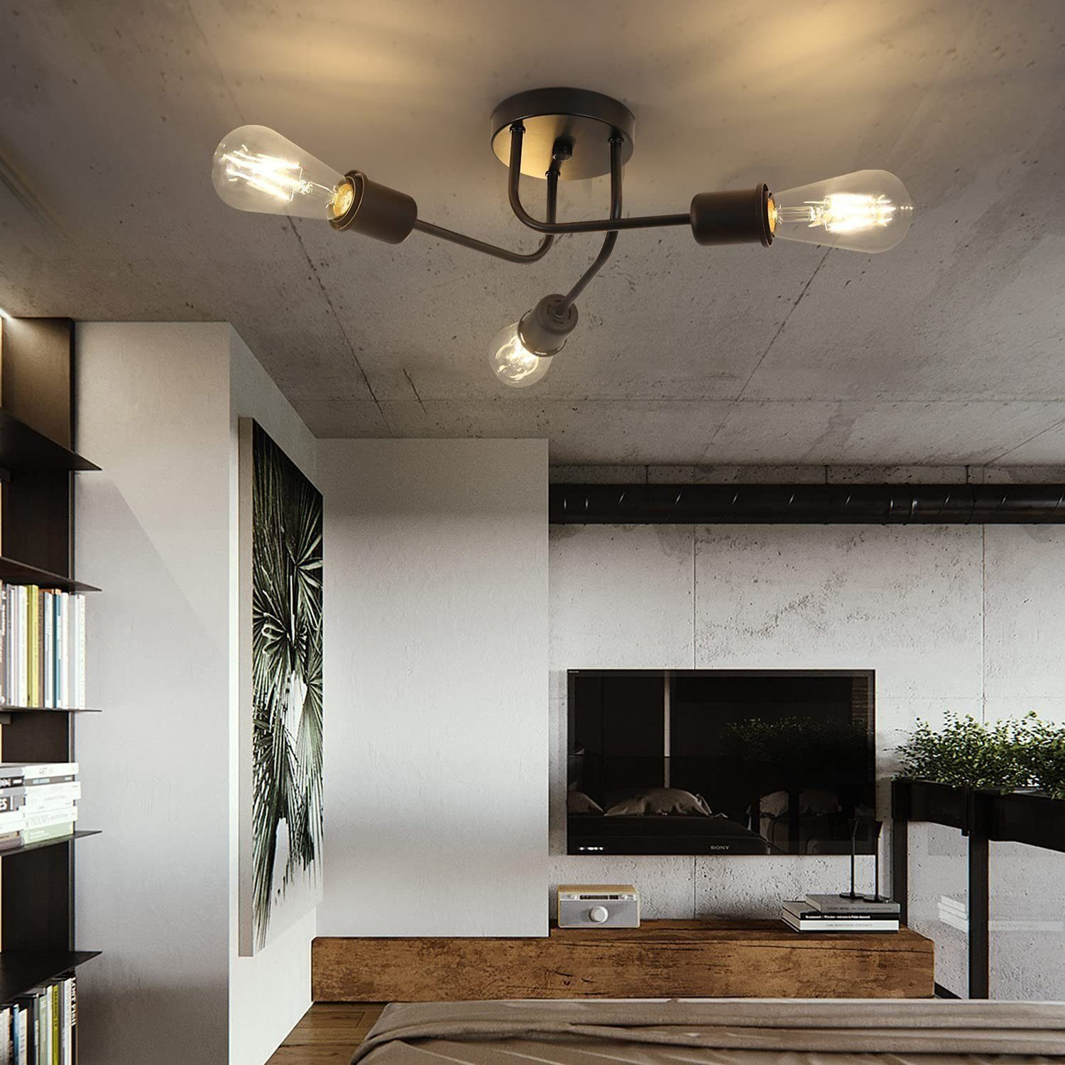 Soffitto con tre lampadine e un apparecchio scuro. Muro in cemento e bianco.