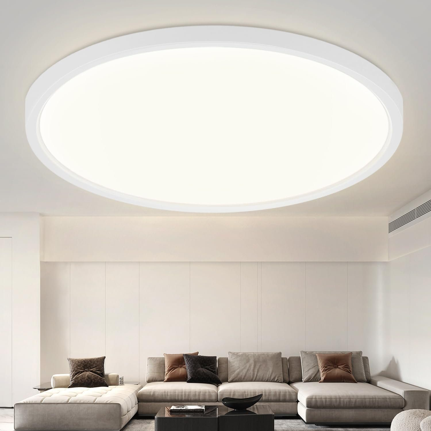 Una luce da soffitto rotonda bianca illumina un soggiorno con un divano beige.