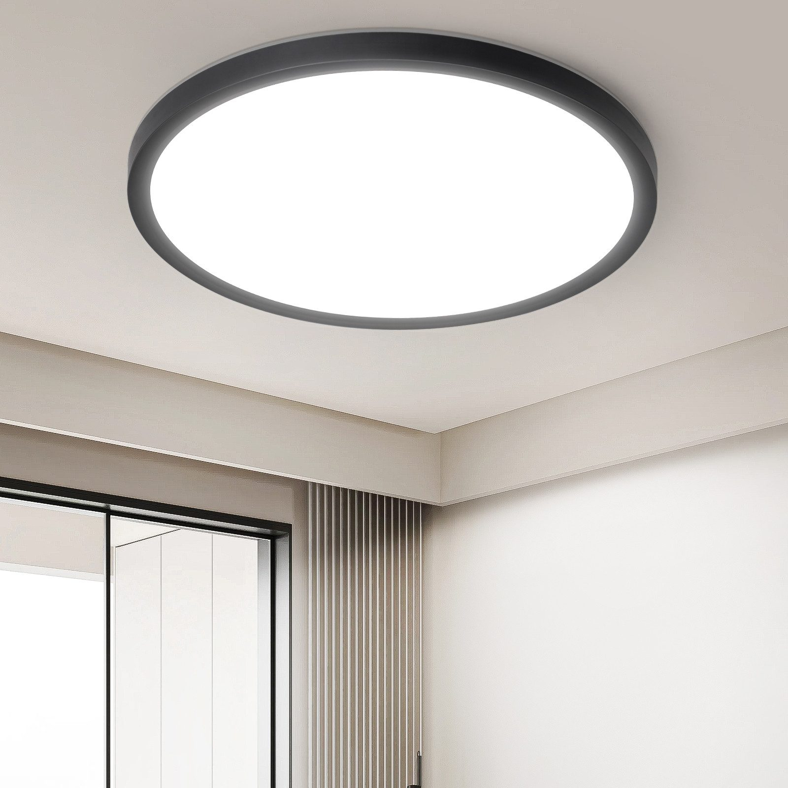 Una luce da soffitto rotonda e bianca con un anello esterno nero installata su un soffitto bianco.