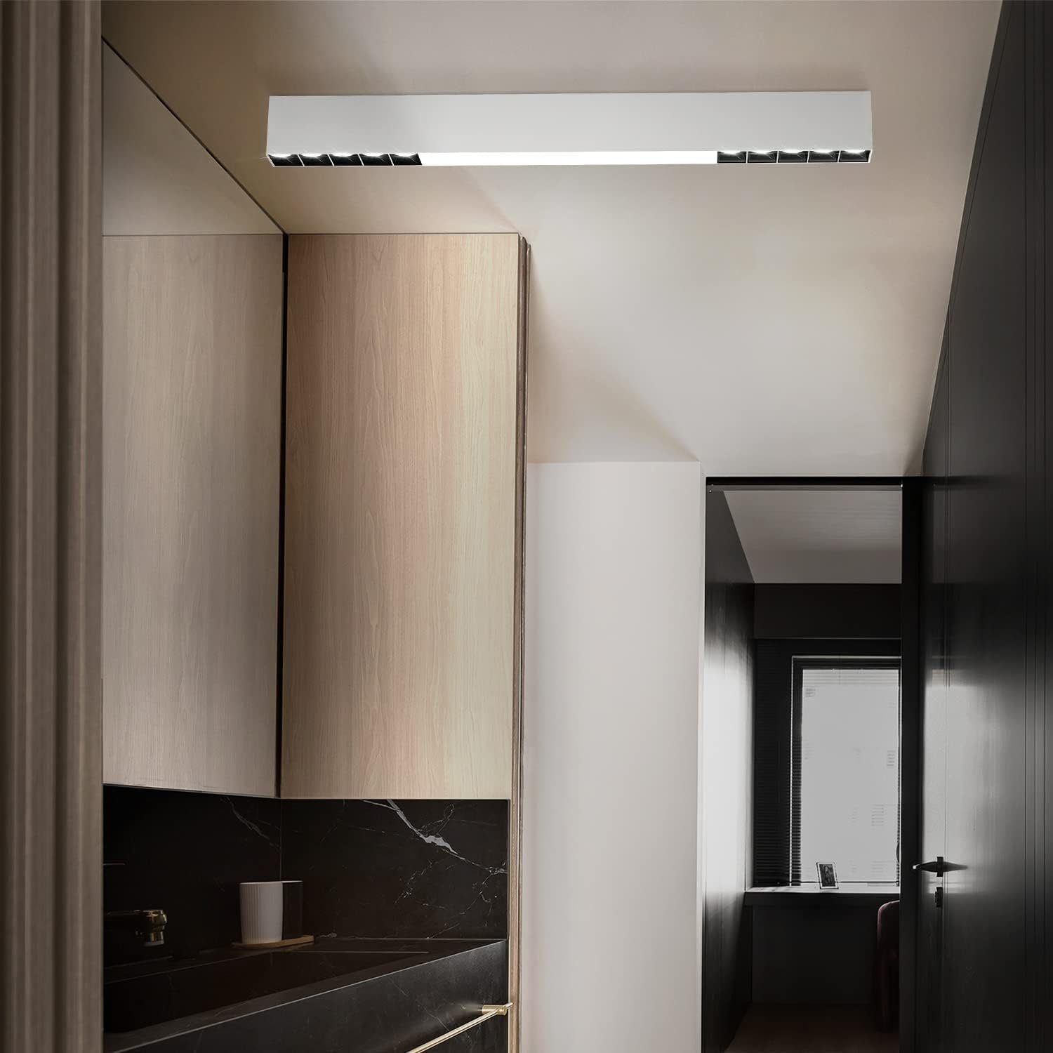 Interno di corridoio con armadi in legno, un lampadario e una porta scura.