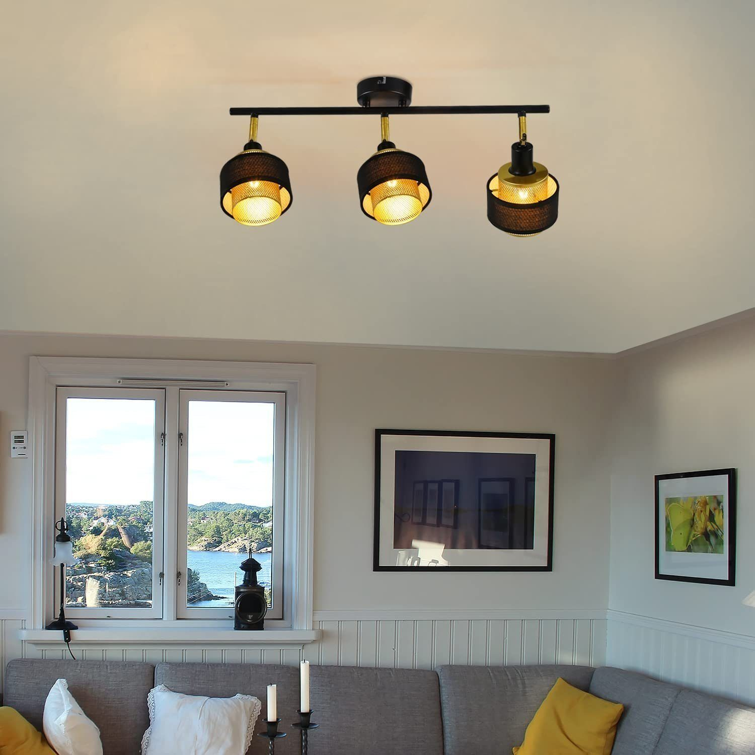 Lampada da soffitto con tre faretti neri regolabili, su un soffitto bianco, con una finestra sullo sfondo.