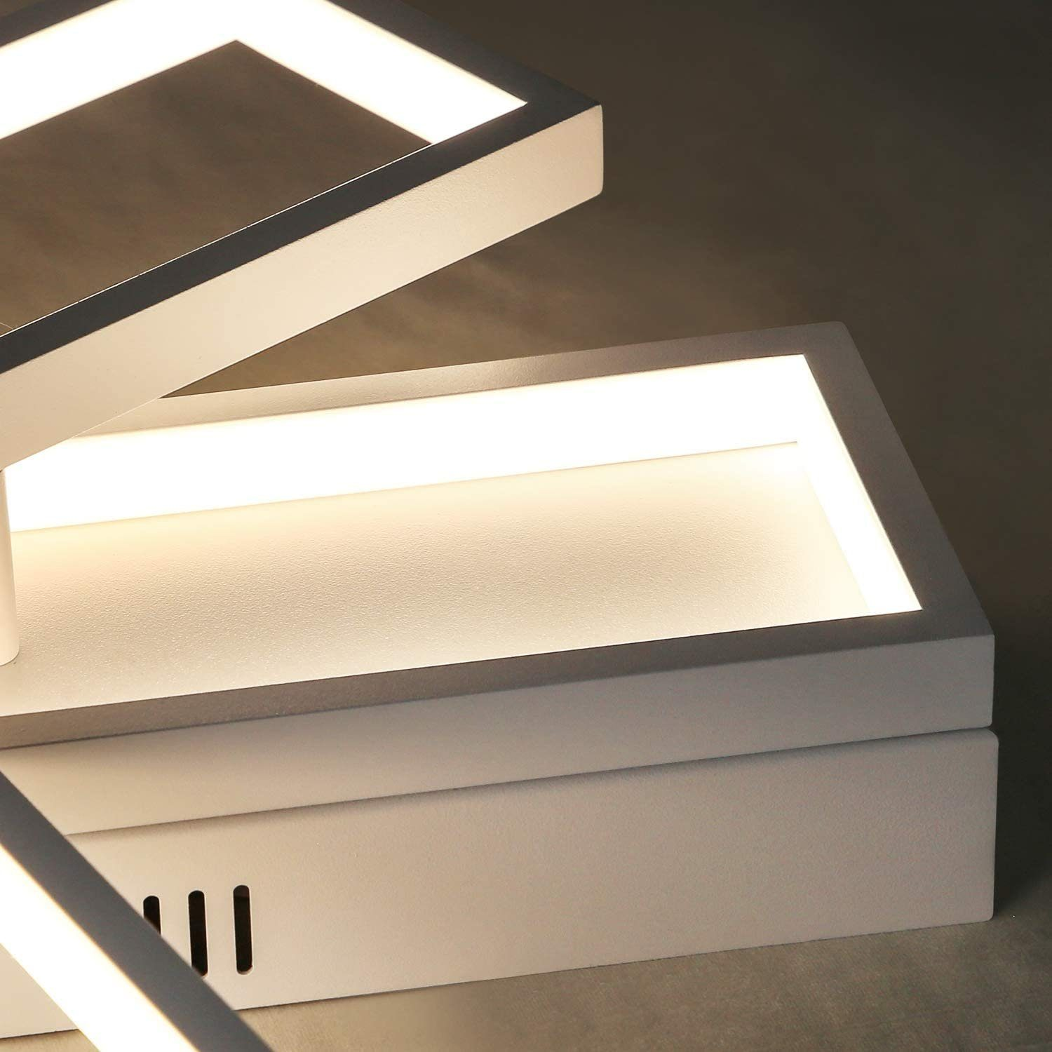 Primo piano di apparecchi di illuminazione a LED rettangolari bianchi, che mostrano un bagliore luminoso.