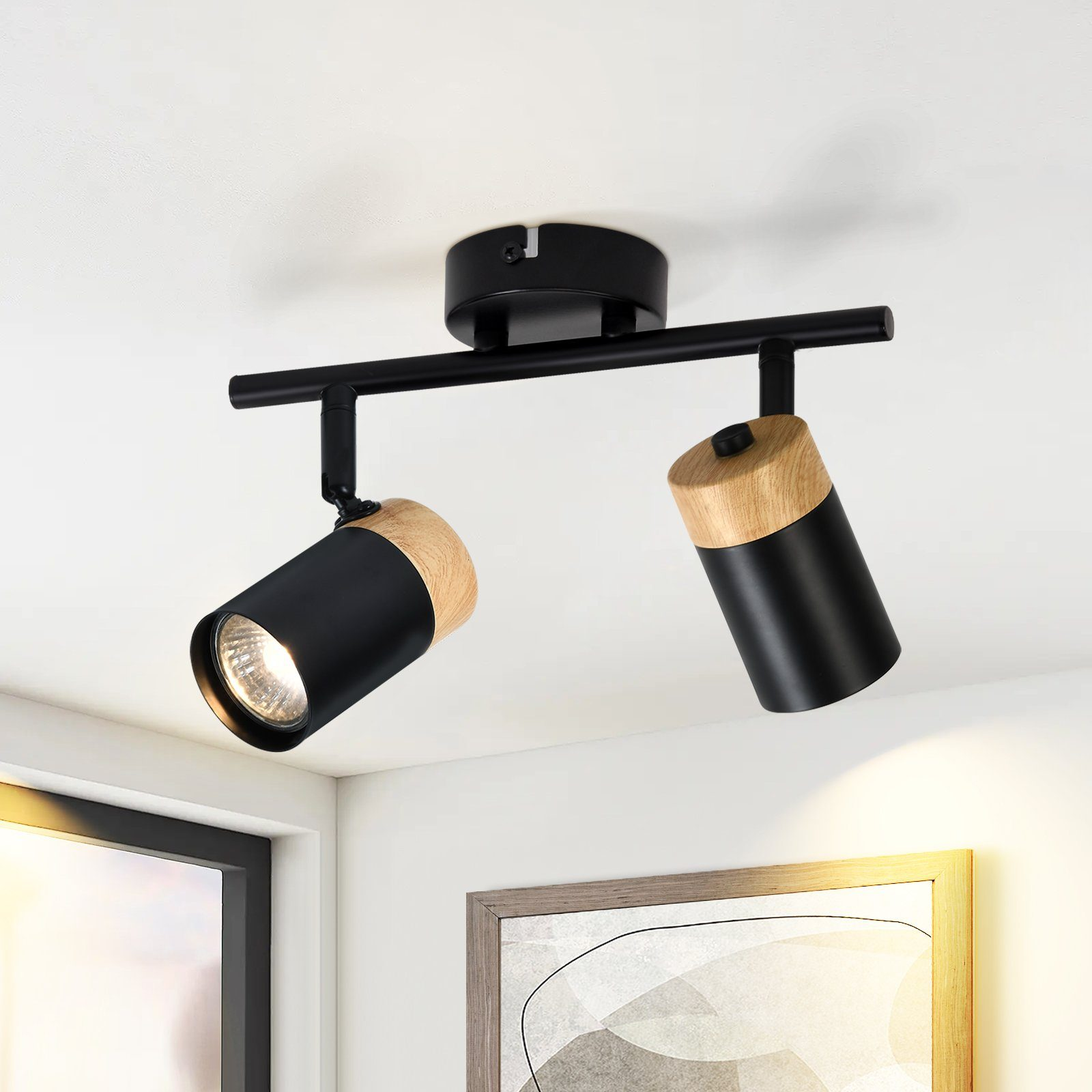 Apparecchi di illuminazione neri montati su una barra nera. Ogni faretto ha un accento in legno. Lo sfondo è un soffitto bianco.