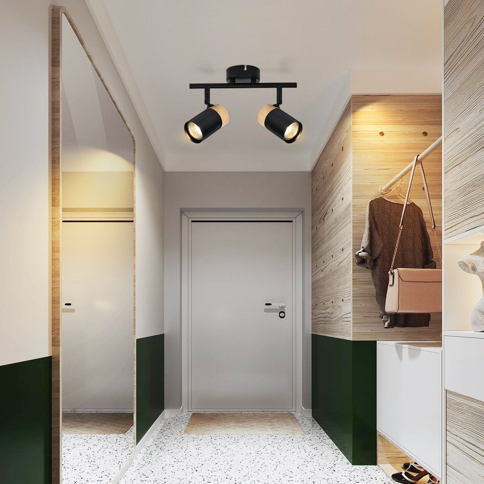 Faretti a soffitto sopra un corridoio con specchio, porta e pannelli in legno.