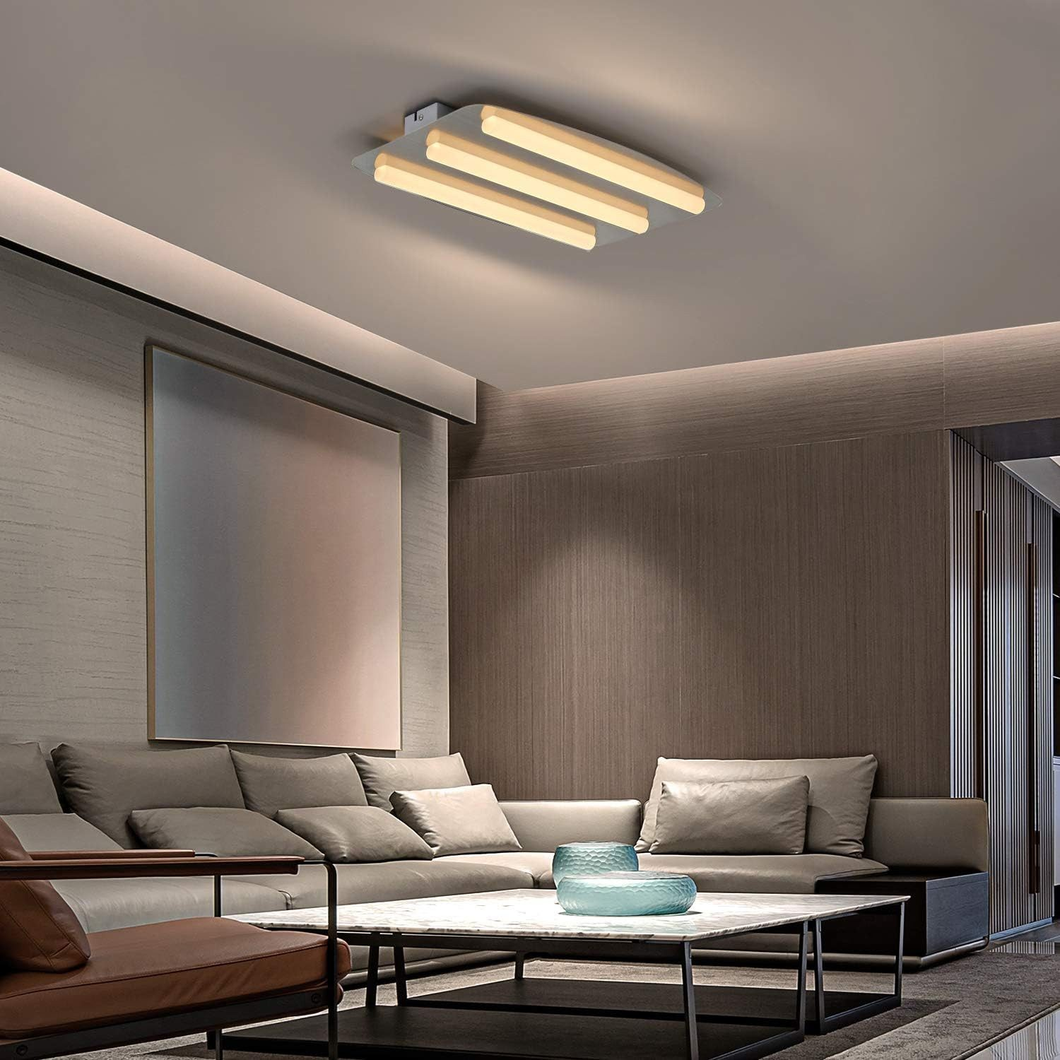 Soggiorno moderno con lampada da soffitto, divano, opere d'arte e vista della stanza.