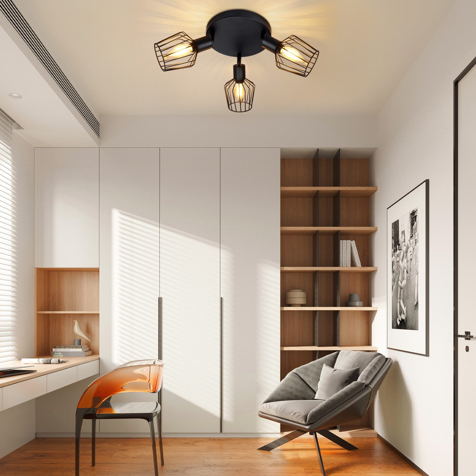 Luci da soffitto nere con gabbie di filo metallico sopra le lampadine. La stanza ha pareti bianche, una sedia e una scrivania.