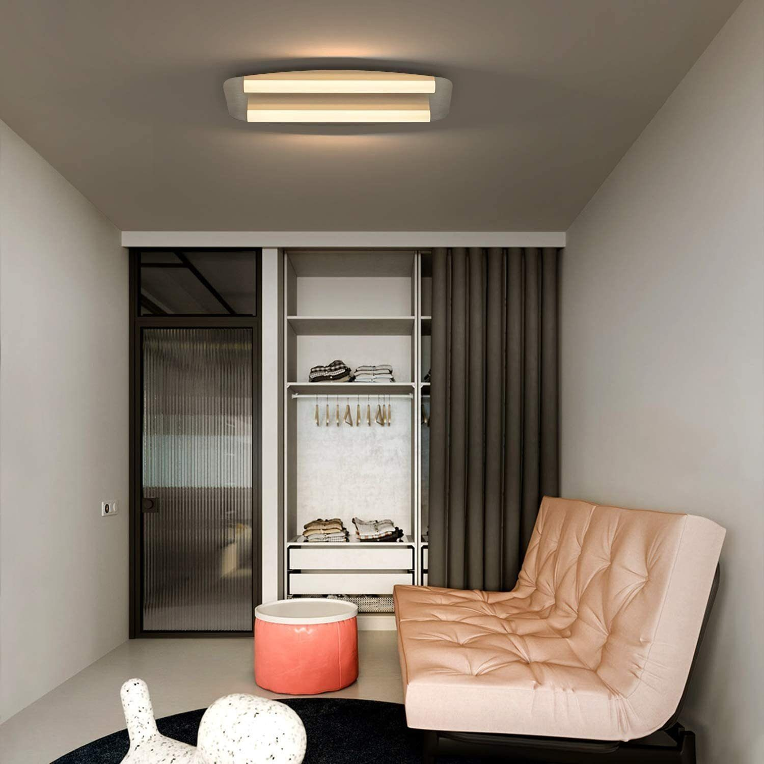 Stanza moderna con divano rosa, armadio e luce a soffitto.