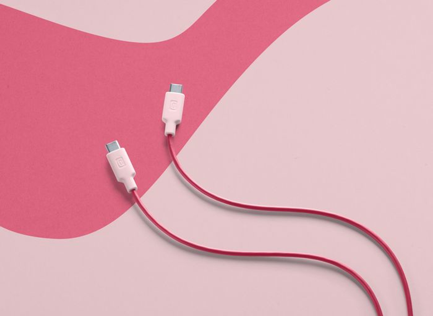 Dos cables USB-C rosas con conectores blancos sobre un fondo rosa y blanco.