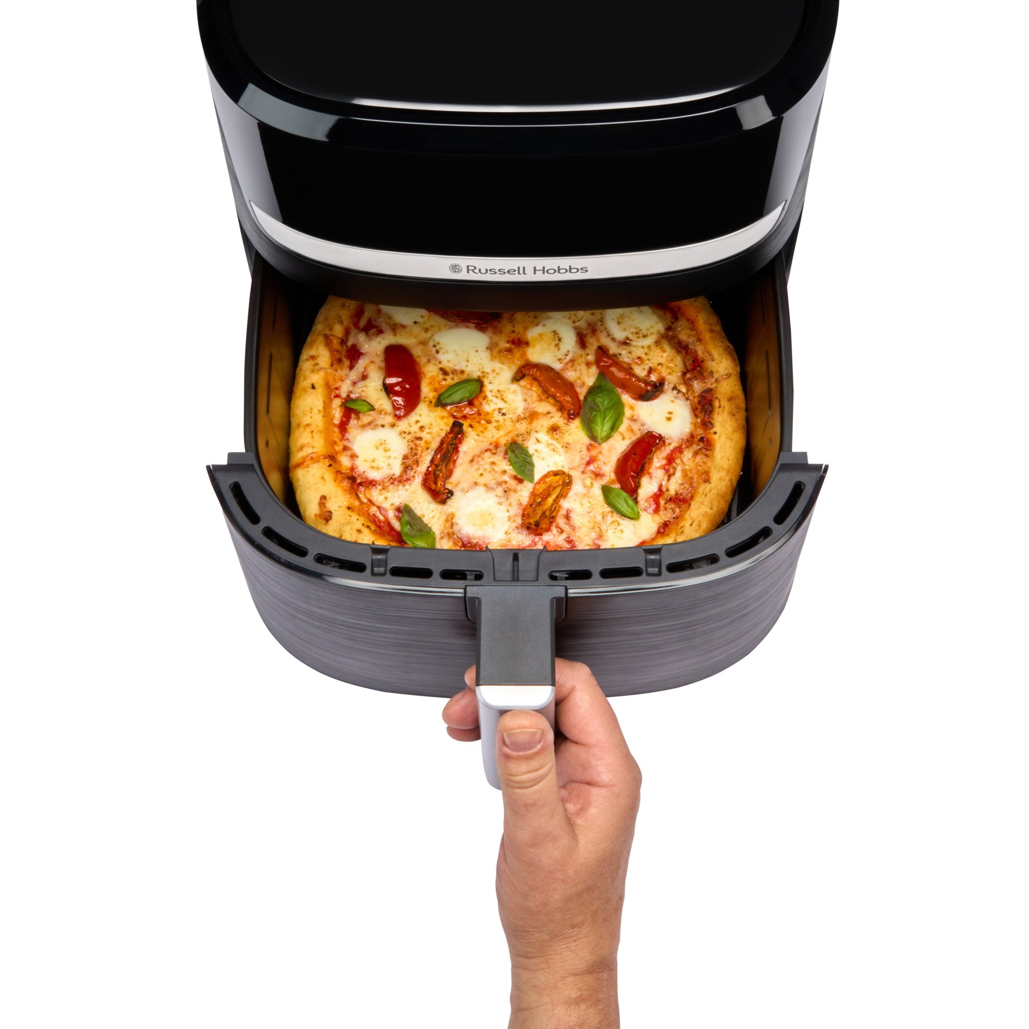 Pizza in einer Heißluftfritteuse, gehalten von einer Hand, mit einer schwarz-grauen Heißluftfritteuse.