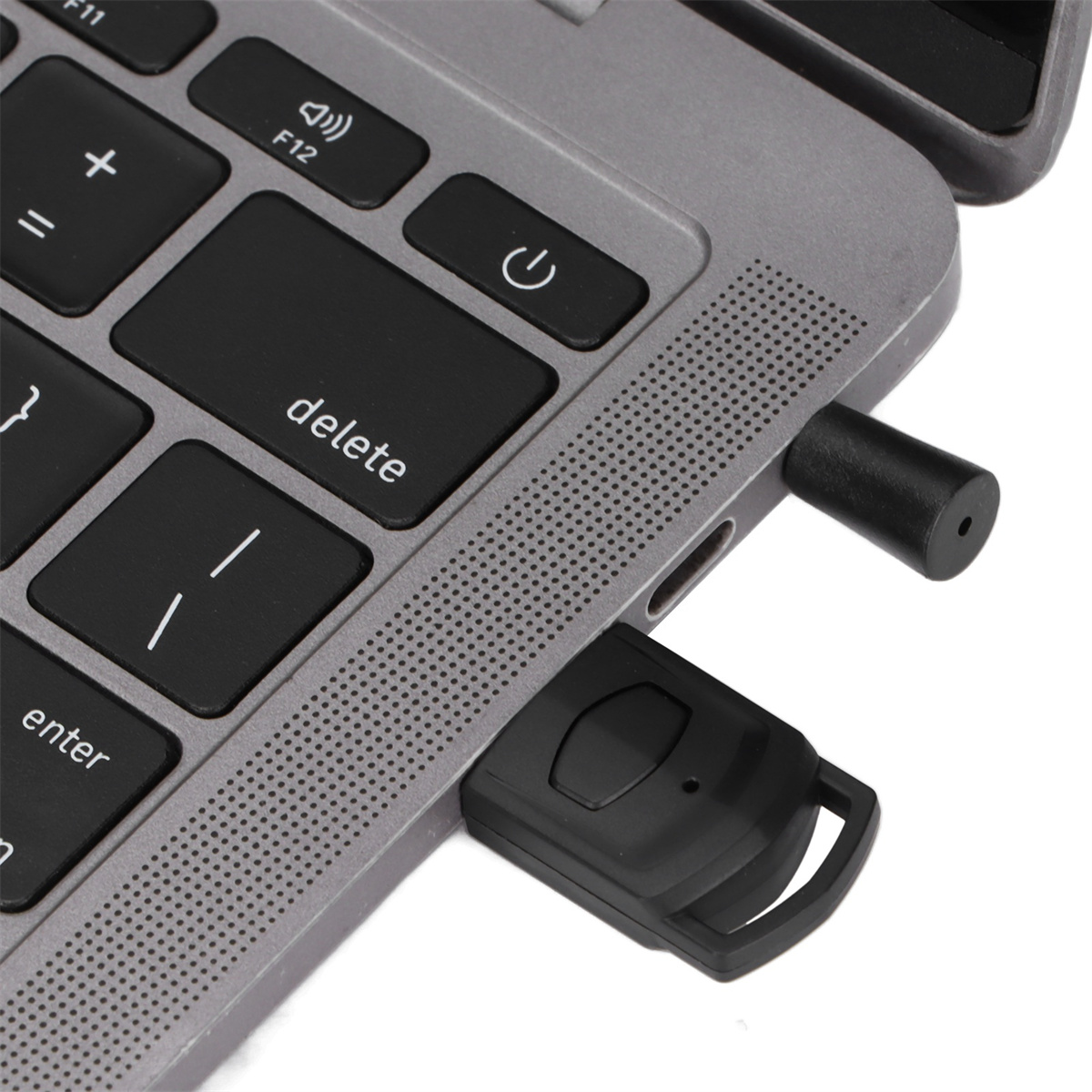 Eine Laptop-Tastatur mit einem USB-C-Anschluss, der mit einem schwarzen Fernbedienungsgerät verbunden ist.