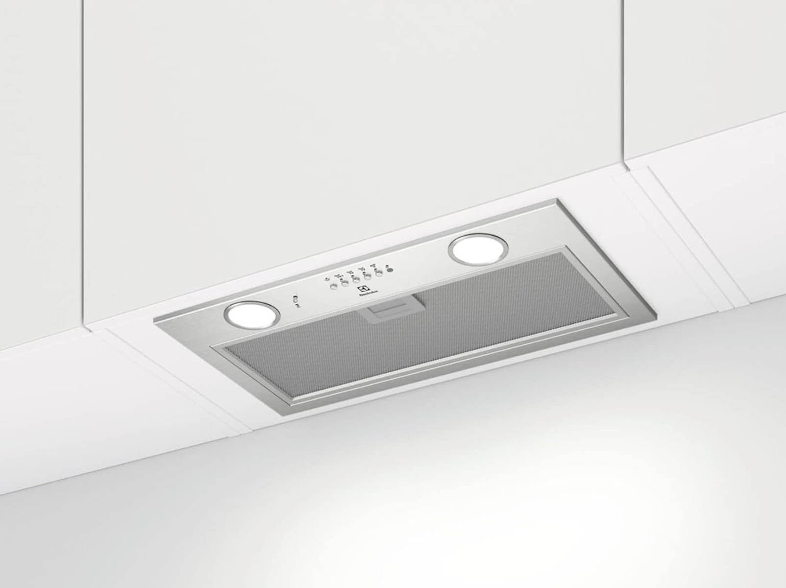 Una campana extractora de acero inoxidable con dos luces está montada sobre una superficie blanca. Tiene un filtro de malla y botones de control.