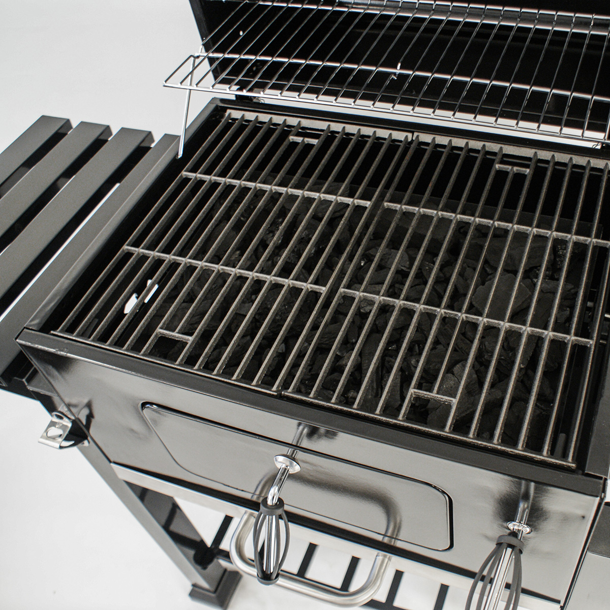 Offener schwarzer Holzkohlegrill mit Holzkohle, Drahtrost. Metall- und schwarze Konstruktion.