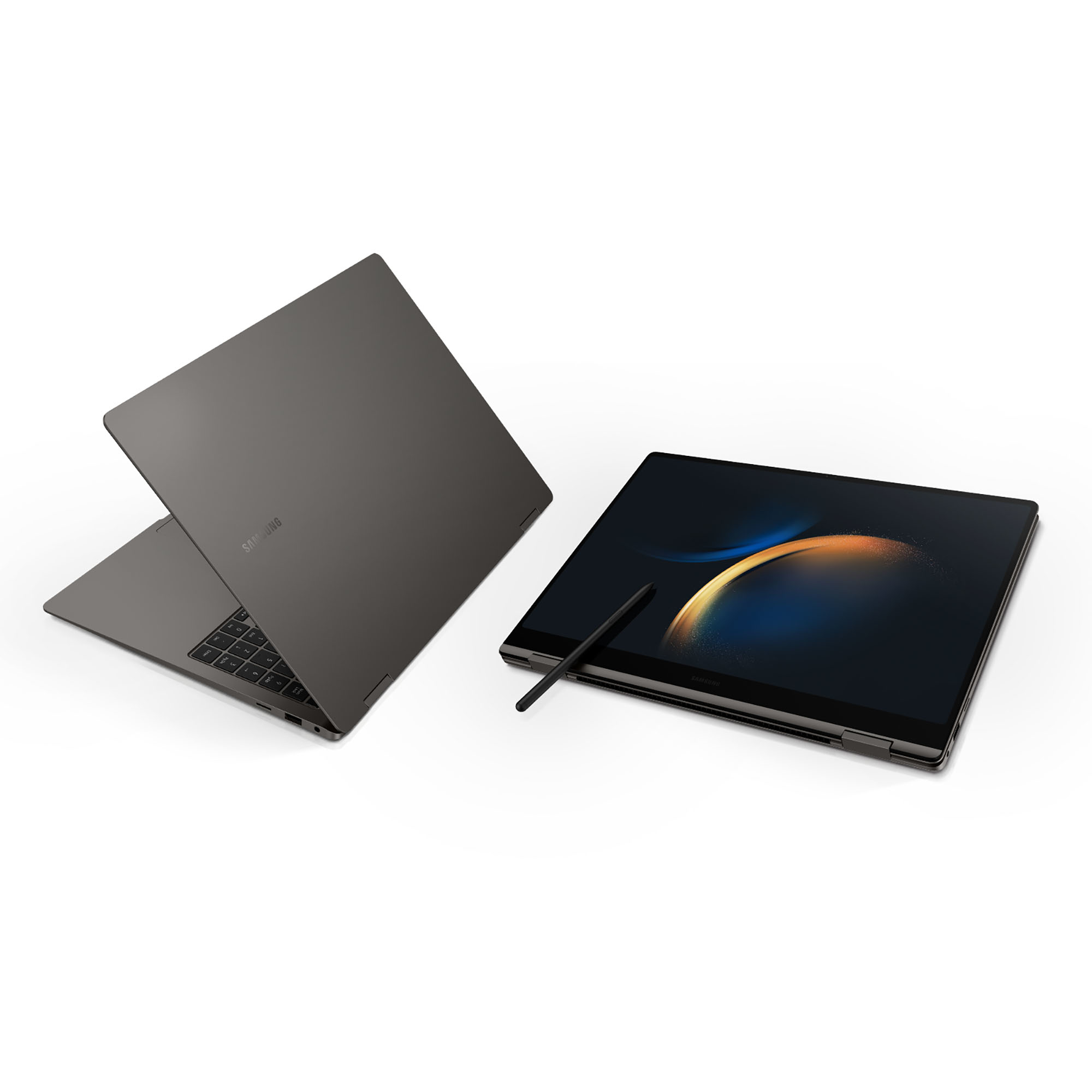 Due laptop grigi, uno aperto e uno chiuso. Una penna stilo è sul laptop aperto.
