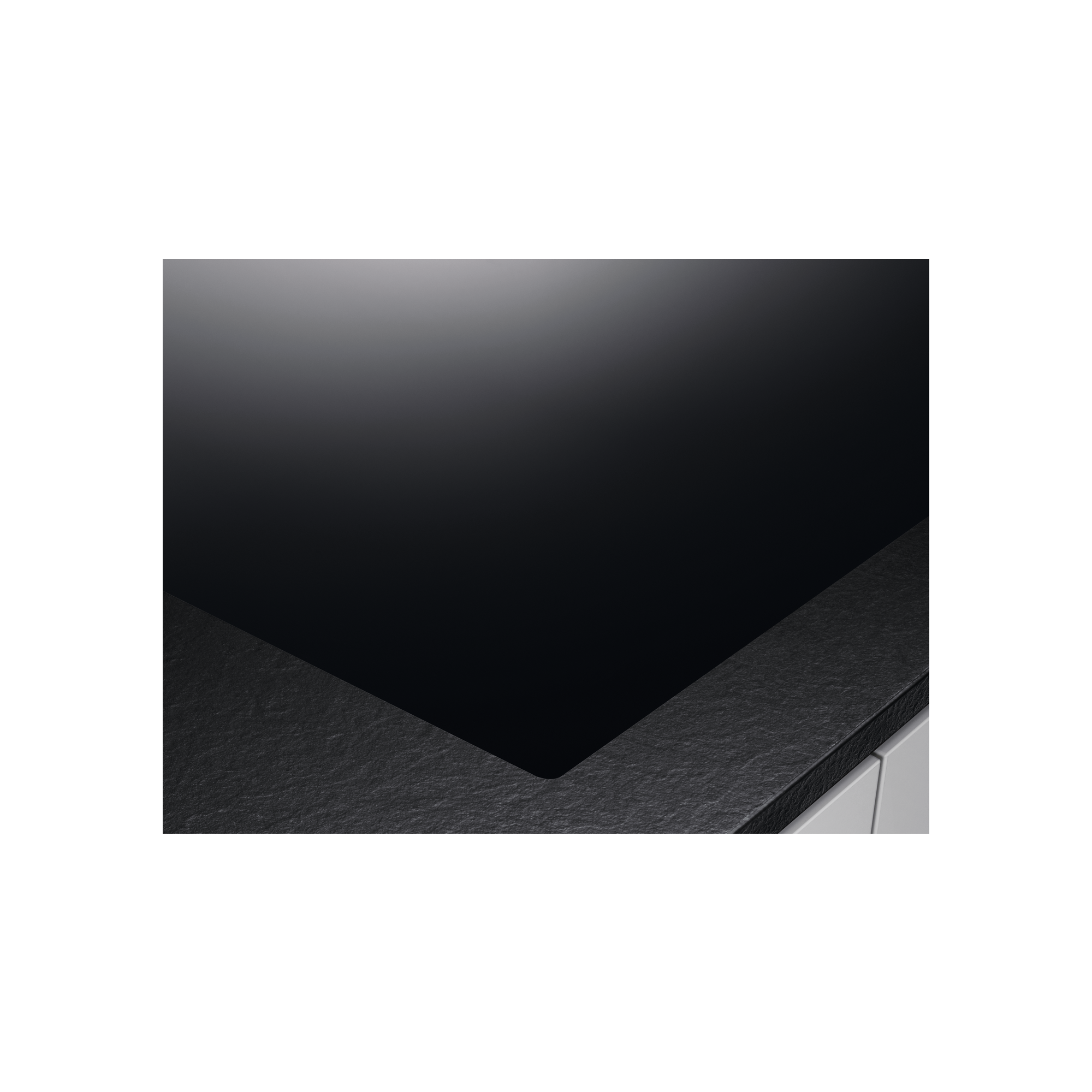 Czarna płyta kuchenna na czarnym tle z czarną krawędzią blatu. Płyta ma błyszczący wygląd.