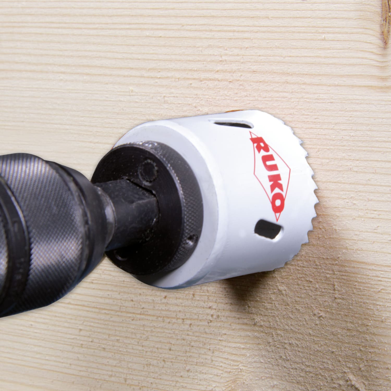 Otwornica w akcji, wiercąca w drewnianej desce.