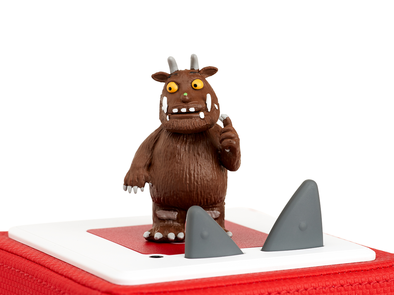 Eine braune Gruffalo-Figur auf einer roten Box, mit zwei haifischflossenartigen Objekten.