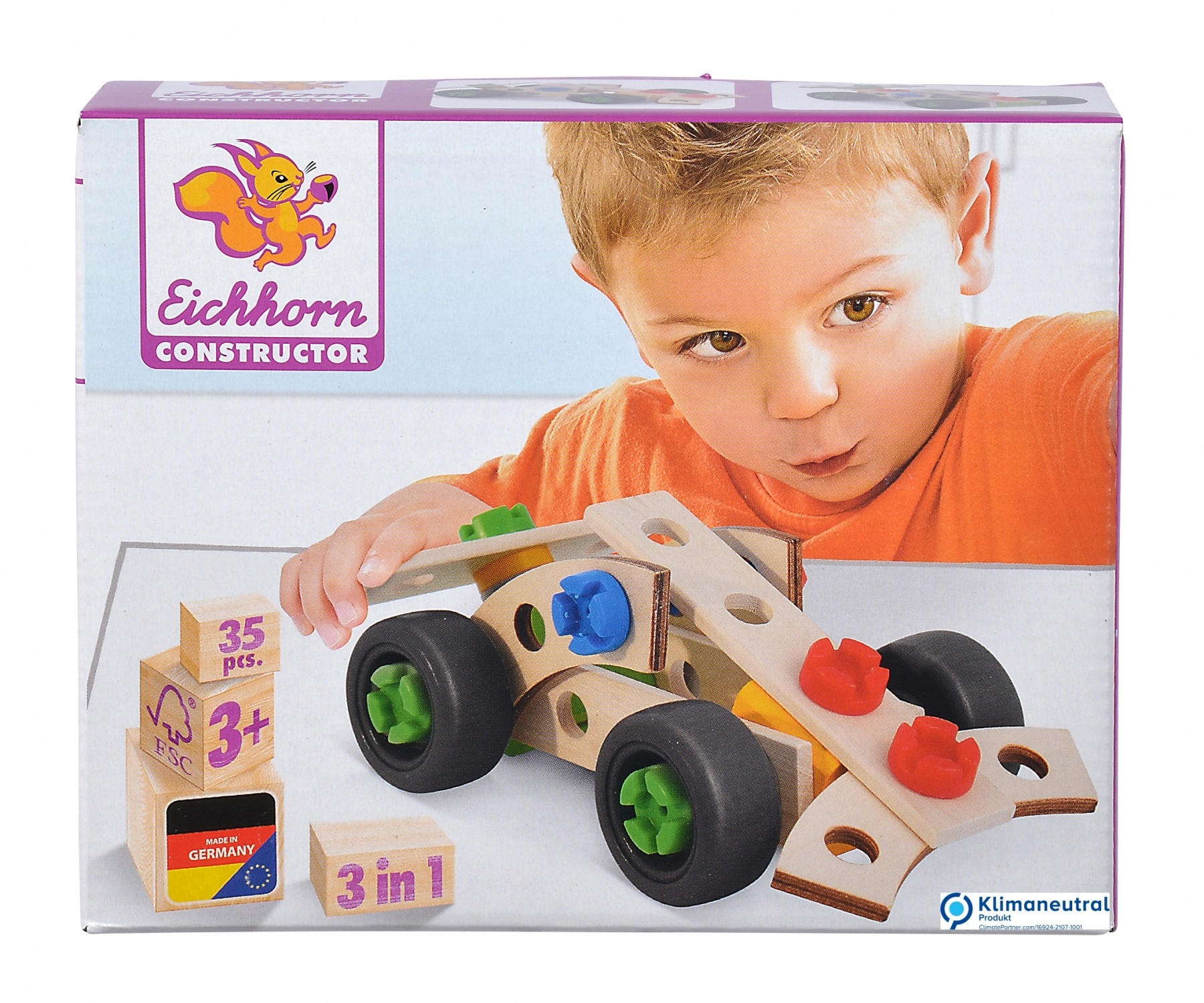 Ein Junge baut ein Spielzeugauto aus Holz zusammen, mit Blöcken, Rädern und anderen Komponenten.