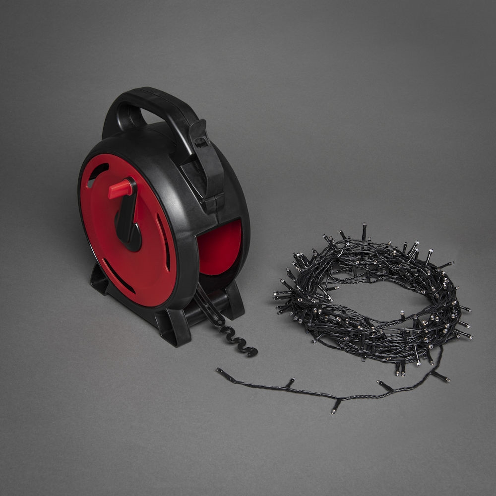 Schwarz-rote Kabeltrommel mit Lichterkette.