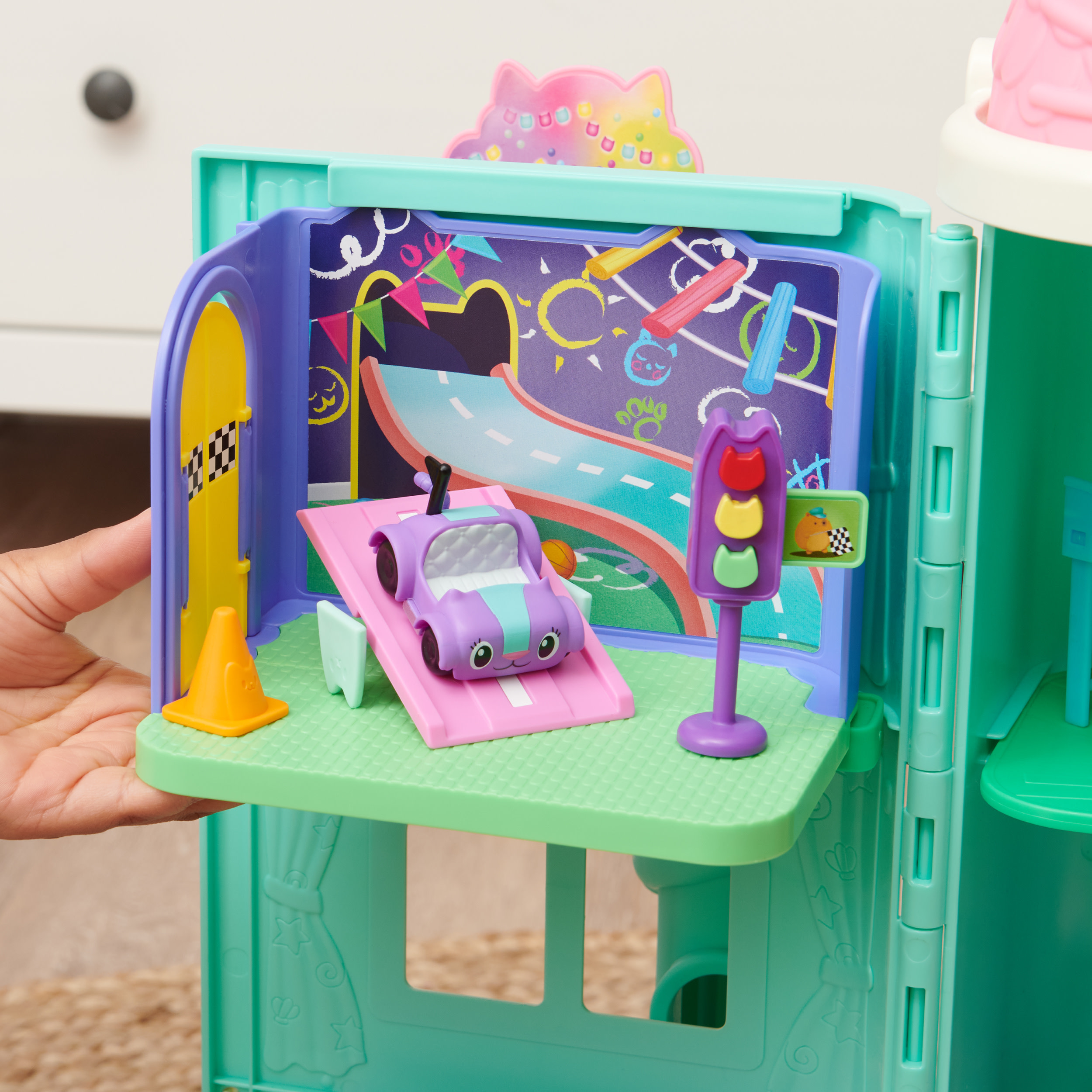 Kinderspielzeug-Spielset mit einem Auto und einer Ampel. Gehalten von einer Hand.