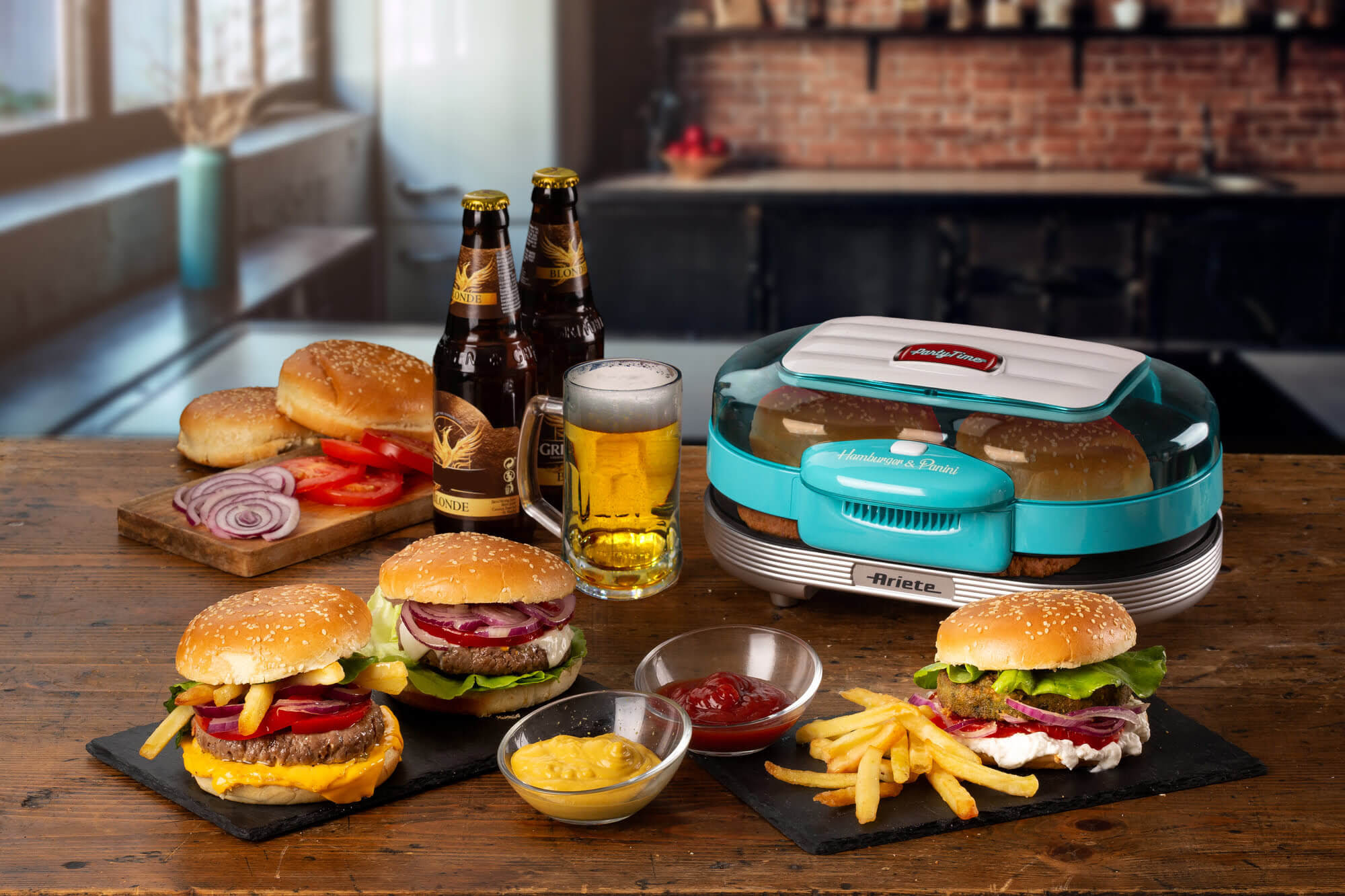 Burgers, friet en bier op een tafel. Een hamburgermaker op de achtergrond.