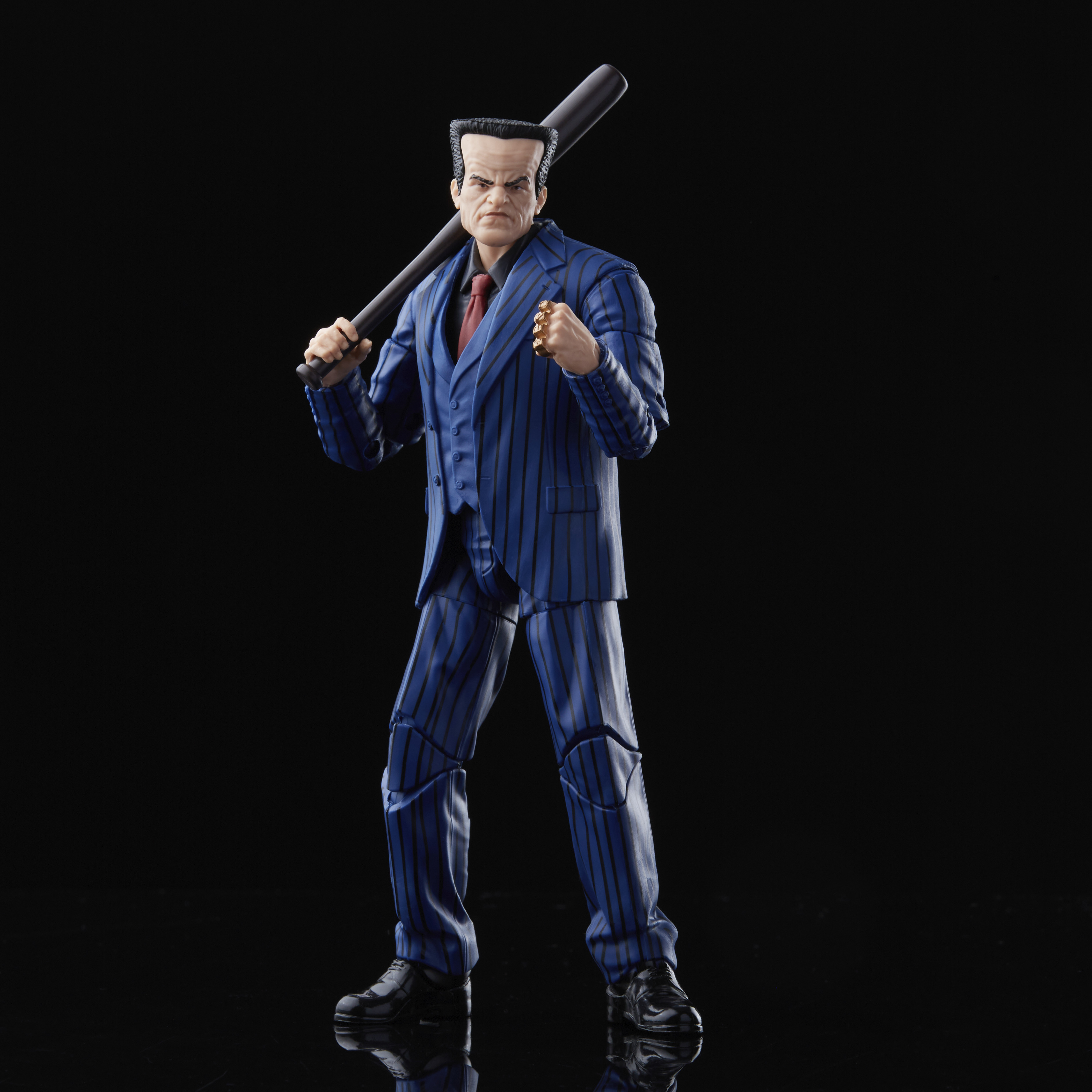 Il cattivo di Spider-Man in abito gessato blu, tiene una mazza. Indossa una cravatta rossa e ha un'espressione minacciosa.