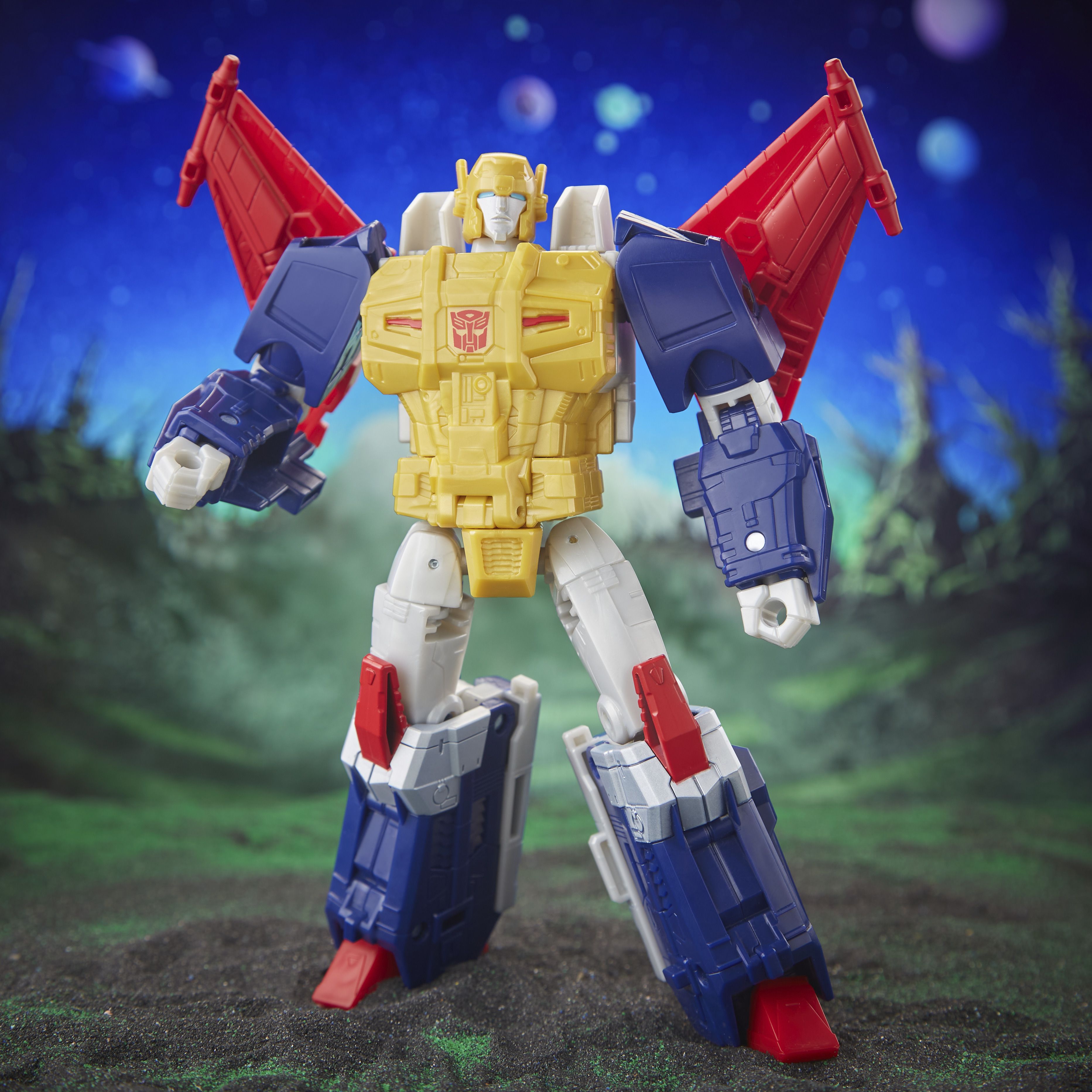 Una figura de acción de Transformers con pecho amarillo, brazos y piernas azules y alas rojas sobre fondo verde.