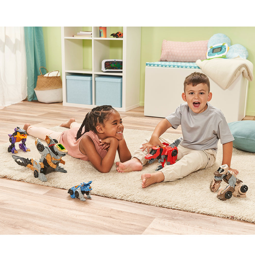 Zwei Kinder spielen mit Spielzeugfahrzeugen auf einem Teppich.
