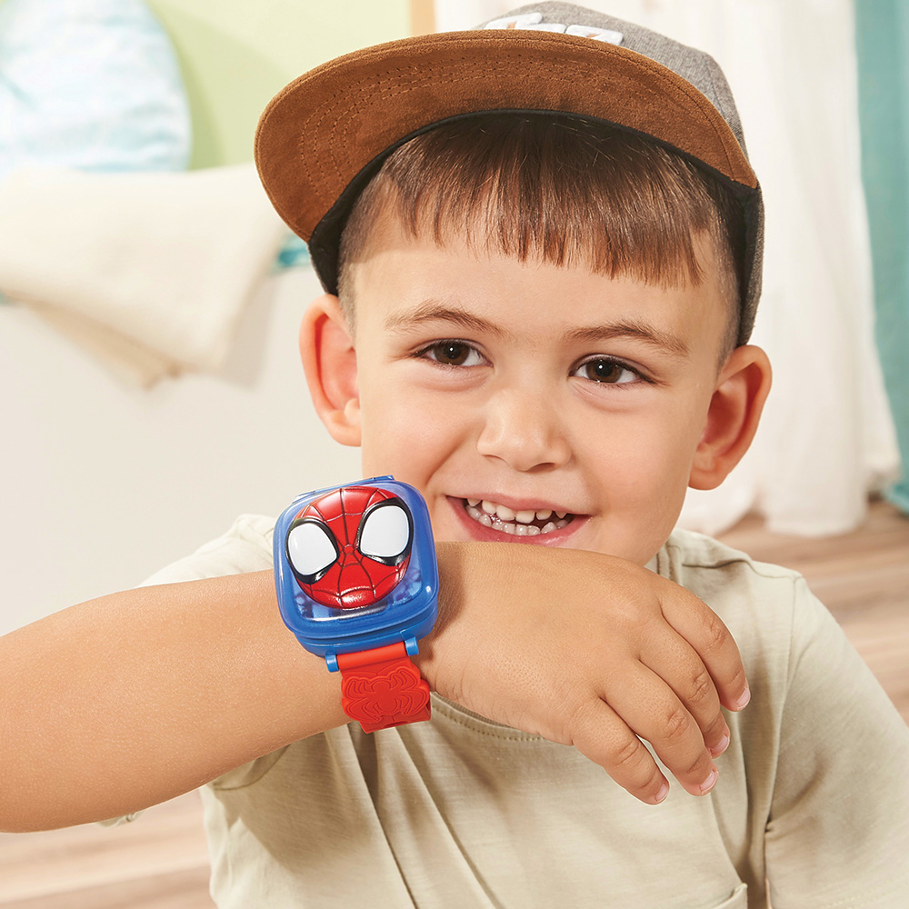 Ein Junge mit einer Spider-Man-Uhr, der in die Kamera lächelt.