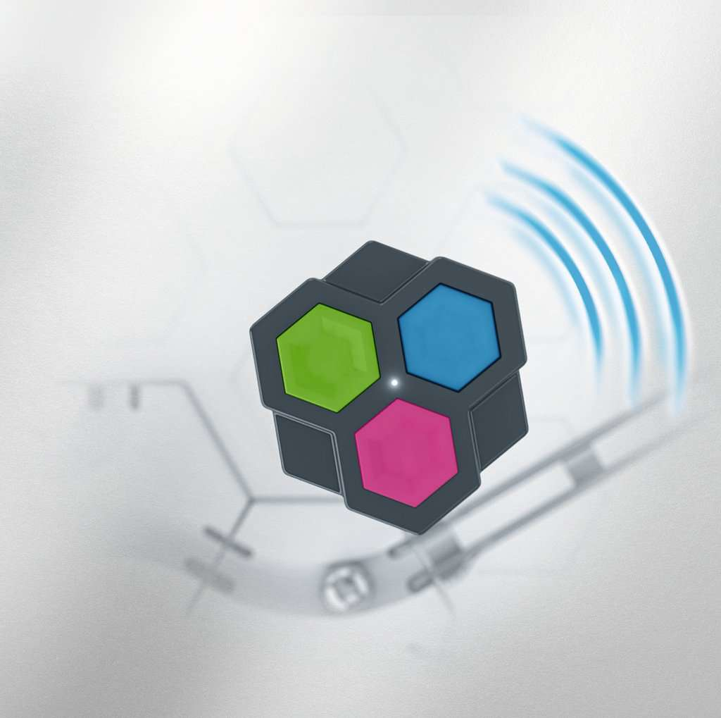 Kostka z trzema kolorowymi sześciokątnymi ścianami: zieloną, niebieską i różową, na rozmytym tle.