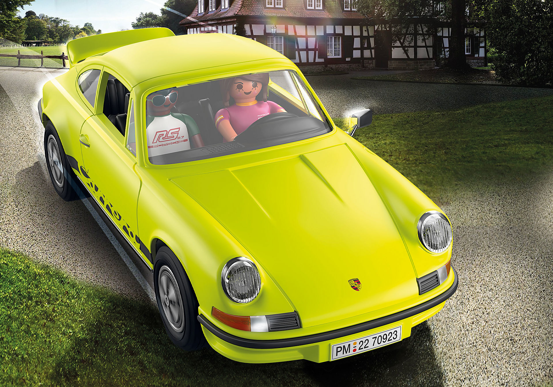 Ein gelbes Spielzeug-Porsche-Auto mit zwei Playmobil-Figuren. Das Auto steht auf einer Straße.