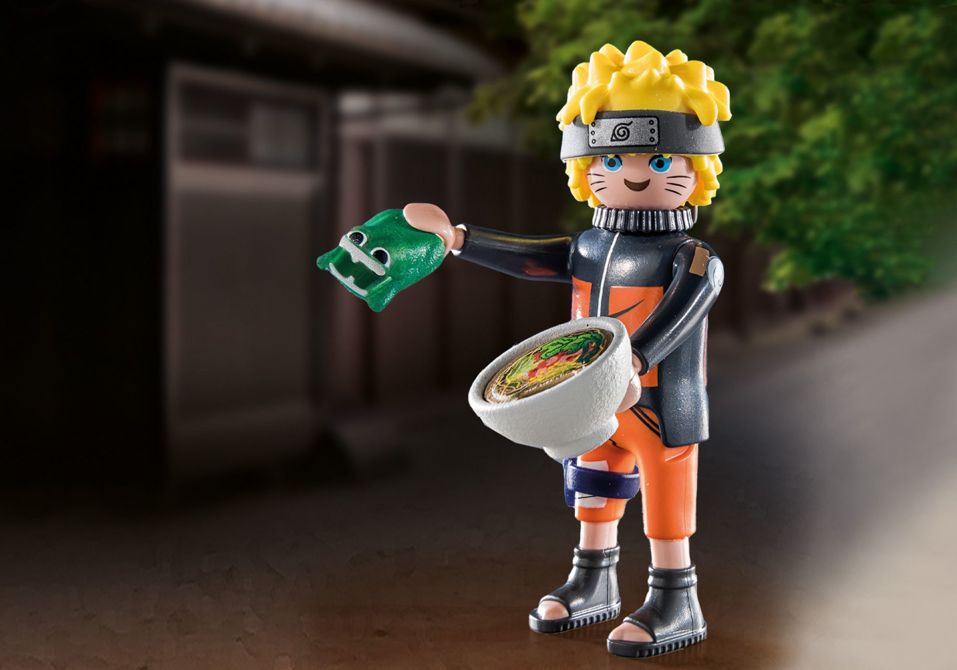 Naruto figuur met een kom ramen, met een groen object, in een straat.