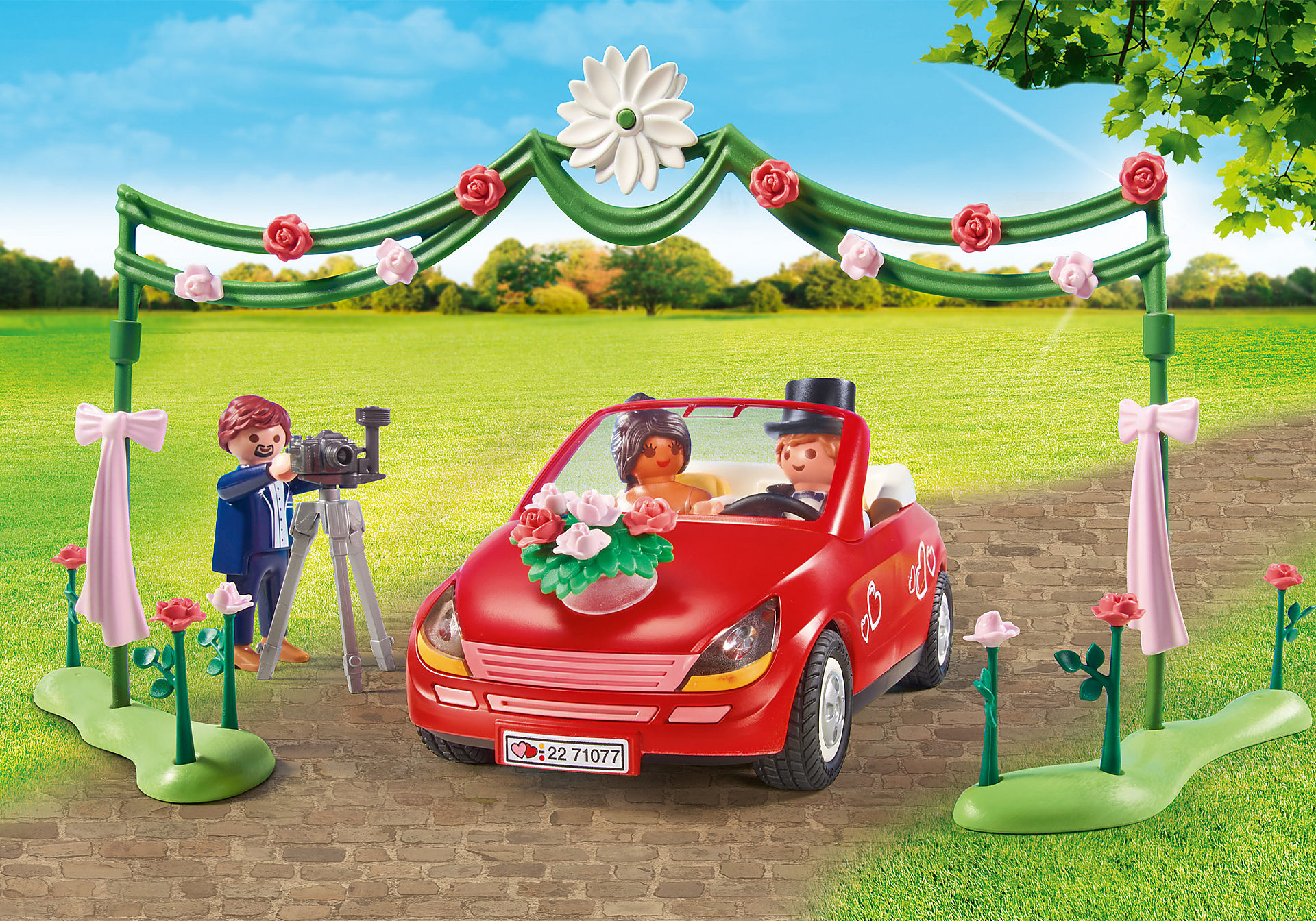 Spielzeug-Hochzeitsszene mit rotem Auto, Braut, Bräutigam und Fotografen.