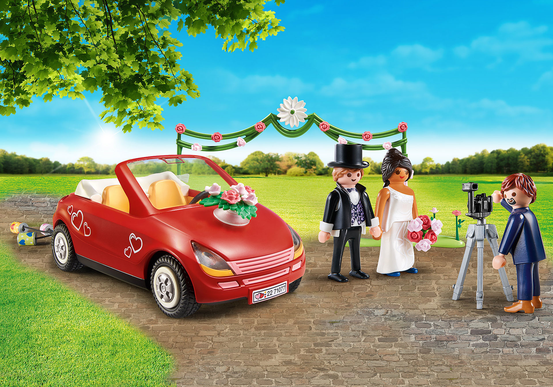 Playmobil Hochzeitsszene. Rotes Auto, Braut, Bräutigam, Fotograf, Torbogen. Grünes Gras, blauer Himmel.