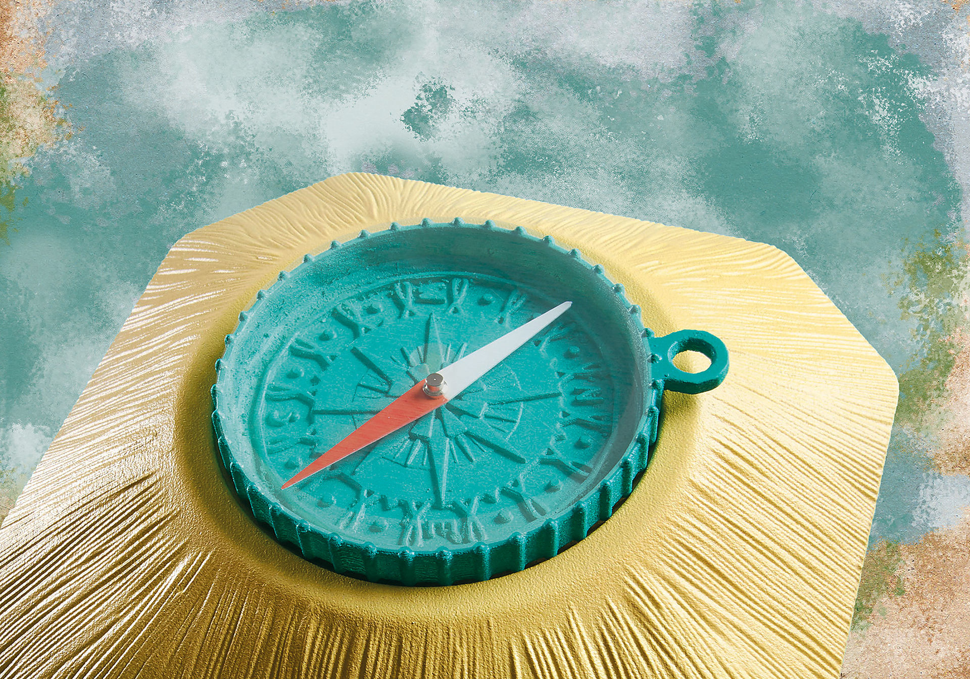 Turkusowy kompas na złotej powierzchni, wskazujący na wschód. Tło to mieszanka turkusu i brązu.