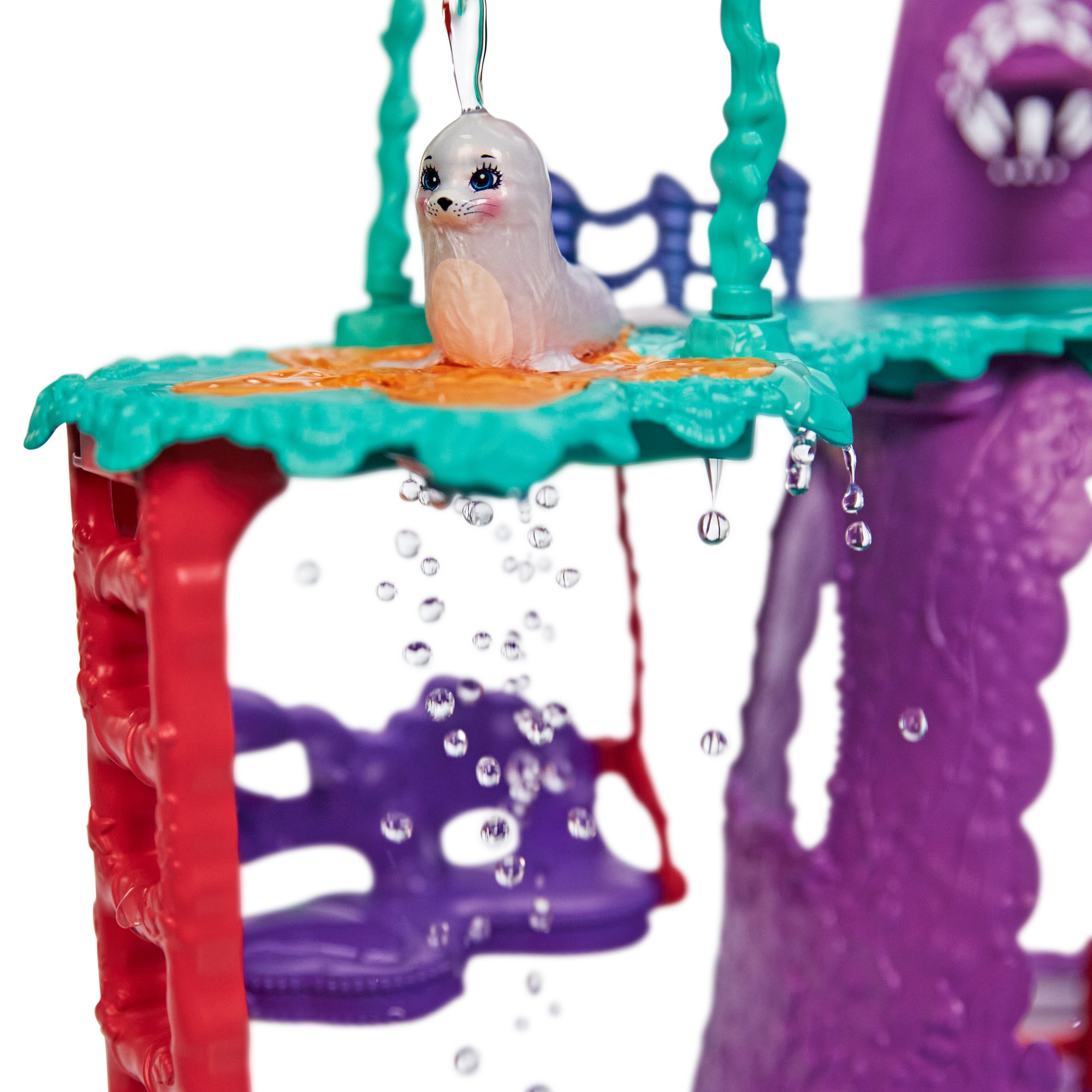 Scena z zabawką z foką na platformie z kroplami wody. Fioletowa konstrukcja jest w tle.