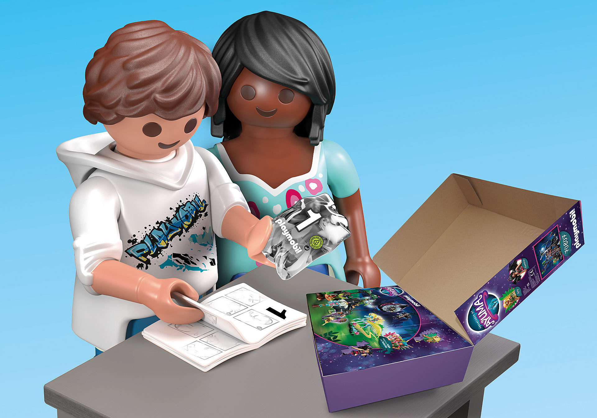 Zwei Playmobil-Figuren schauen auf eine Baukasten-Box, mit Anleitung.