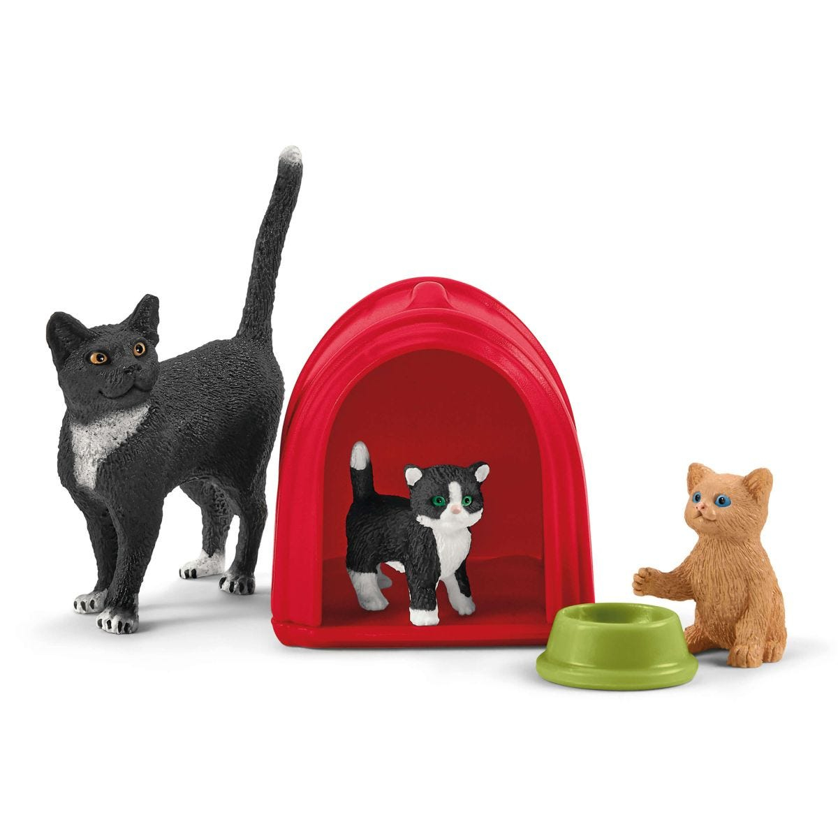 Schwarz-weiße Katzenspielzeuge mit einem roten Haus. Eine grüne Schüssel ist ebenfalls vorhanden.