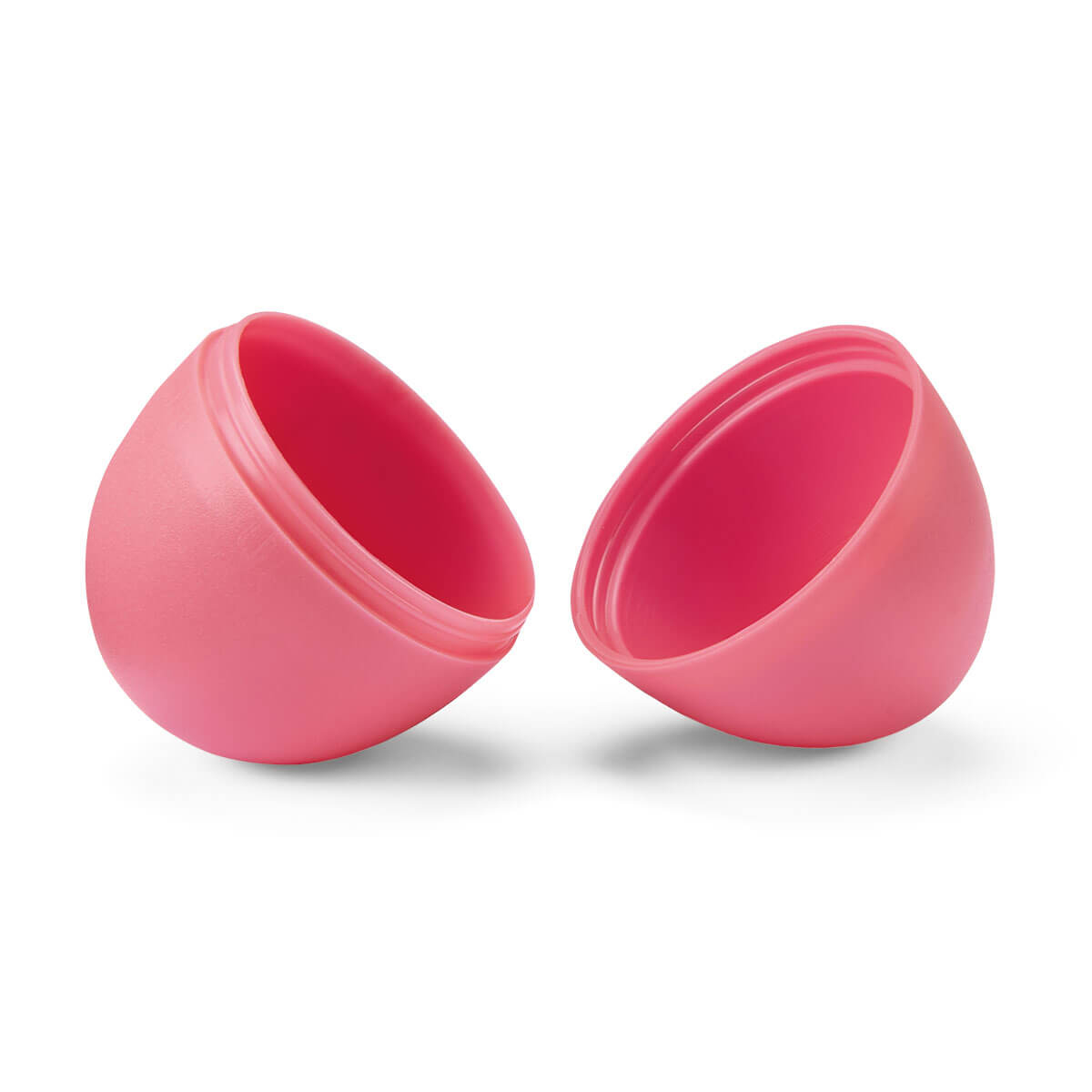 Dwie różowe połówki plastikowego jajka. Są otwarte, odsłaniając wnętrze. Tło jest białe.