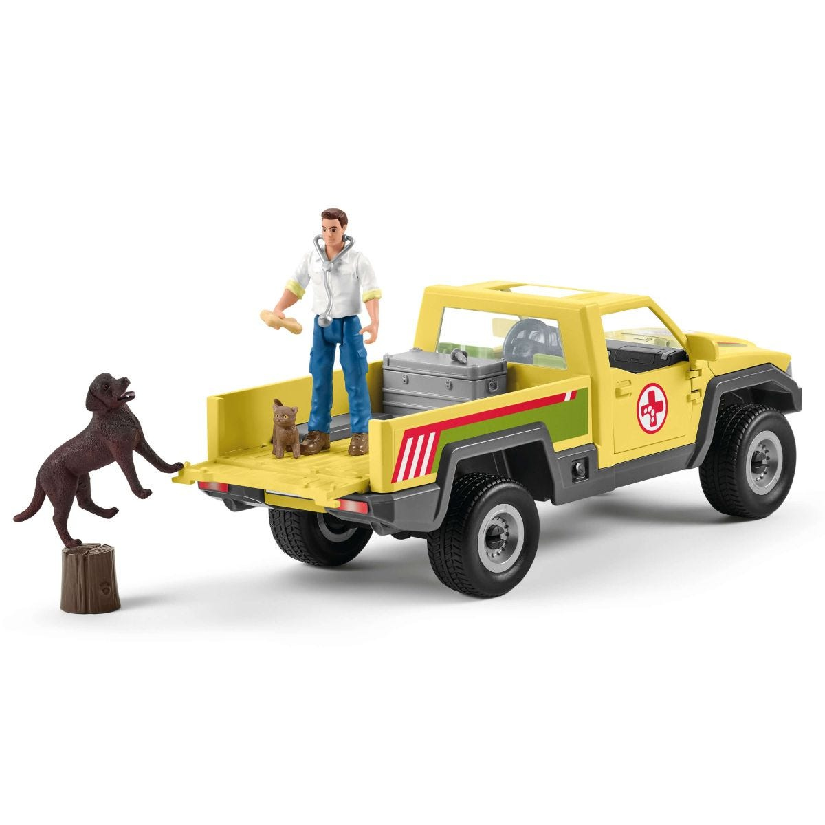 Gelber Spielzeug-LKW mit Mann, Hund und Katze. Der Hund springt auf einen Baumstumpf.