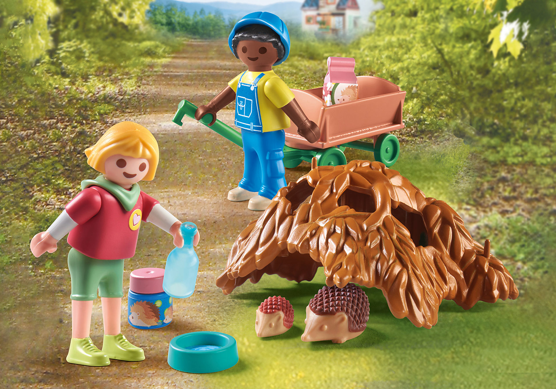 Due figure di Playmobil, un bambino e un ragazzo con un carretto e dei ricci. La scena è su un sentiero in un bosco.