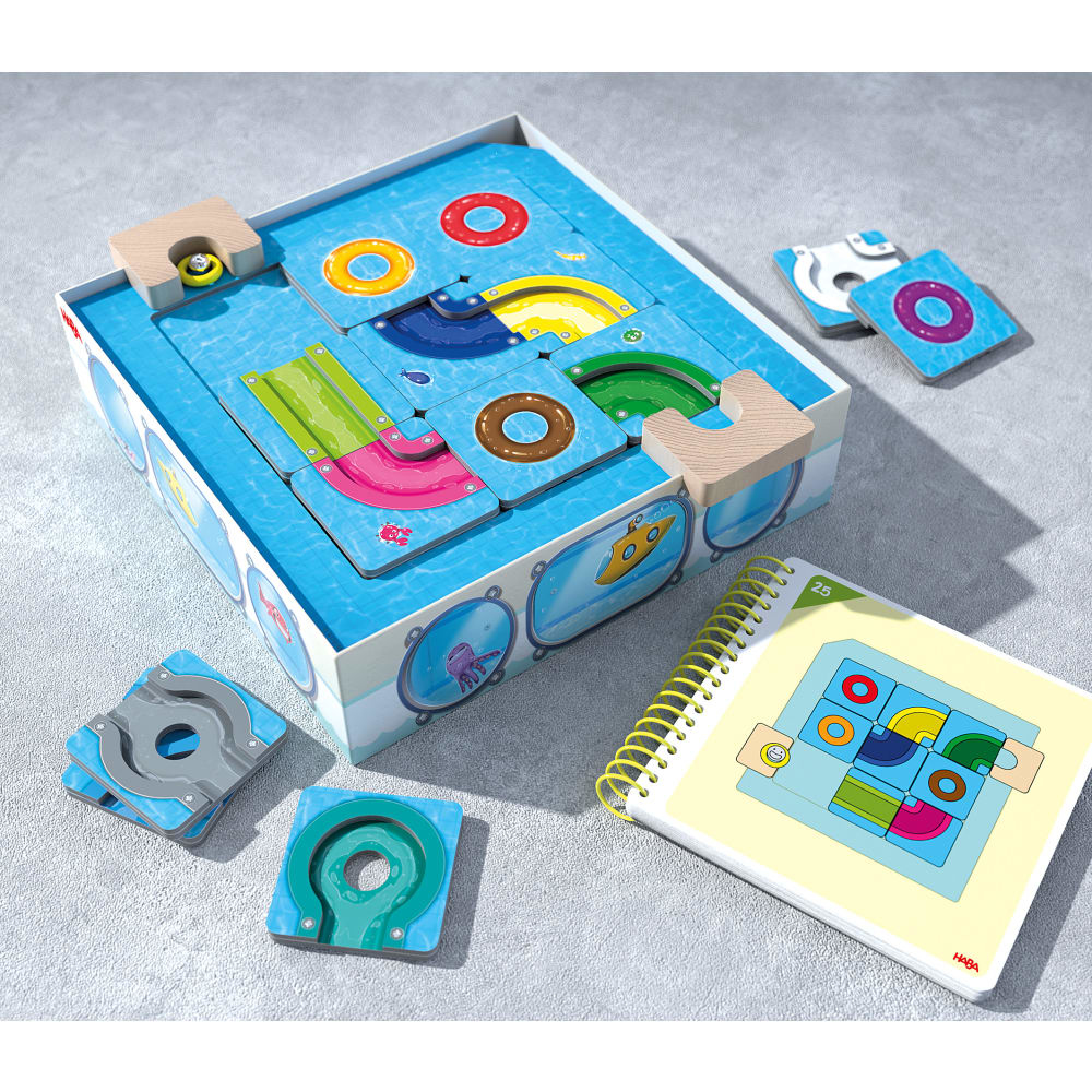 Un gioco di puzzle con pezzi di legno e un libretto, che mostra diversi layout su una superficie blu.