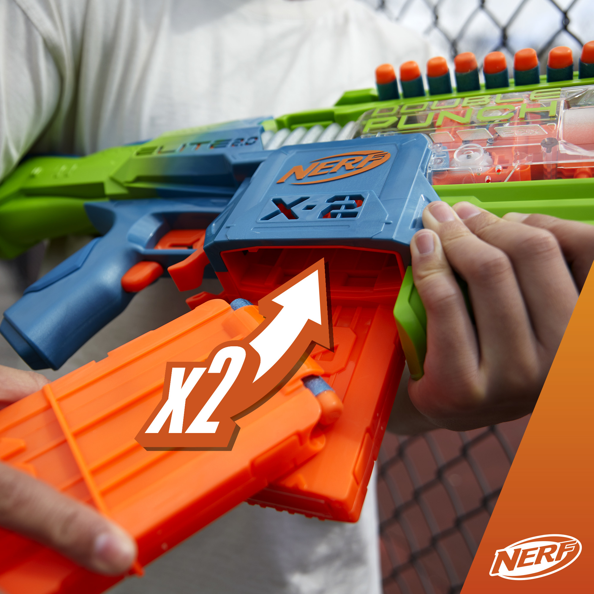 Mani che caricano dardi NERF arancioni in una pistola NERF blu, con una freccia rivolta verso l'alto.