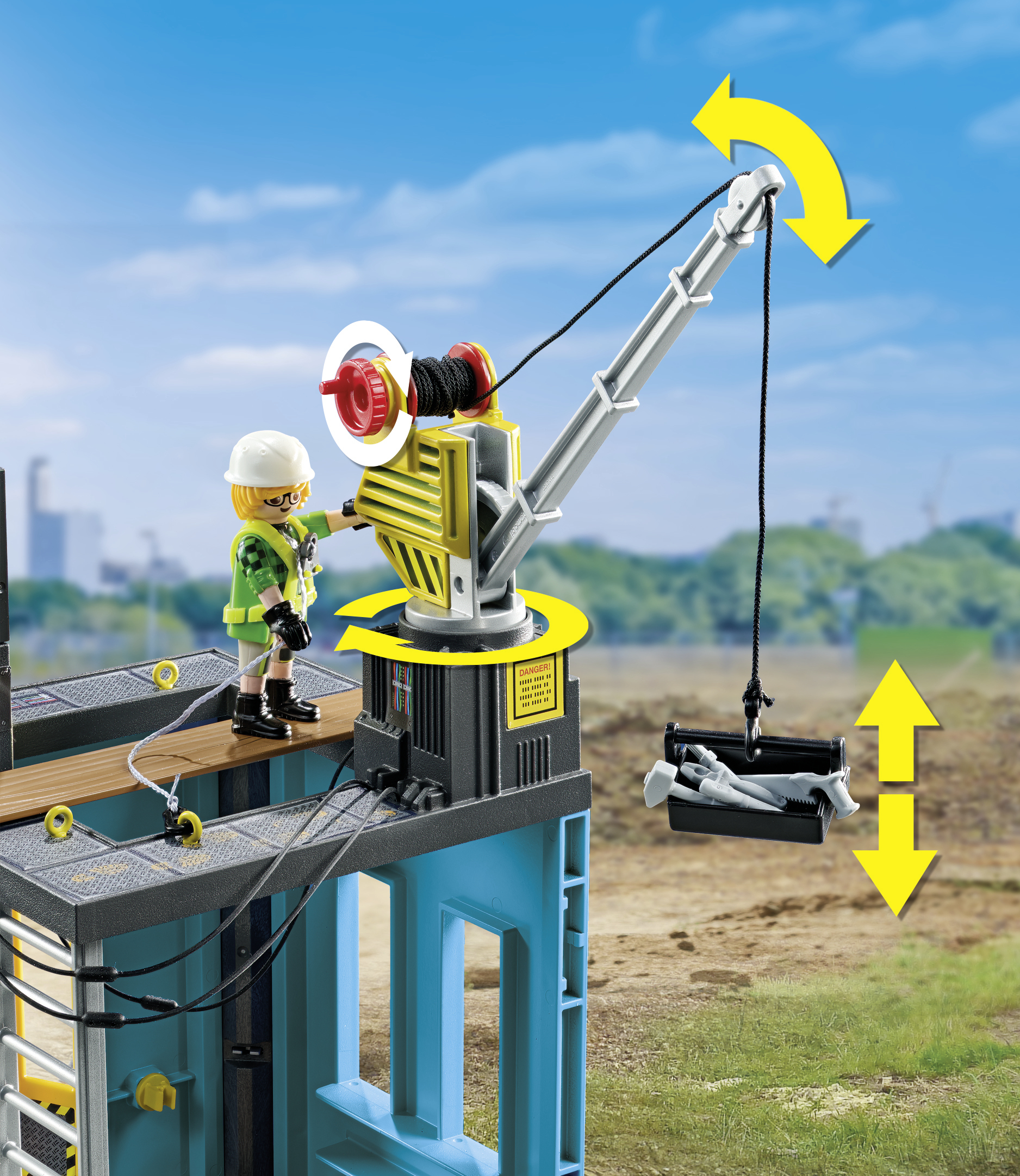 Una scena di costruzione Playmobil con una gru che solleva un container, contro un cielo blu.