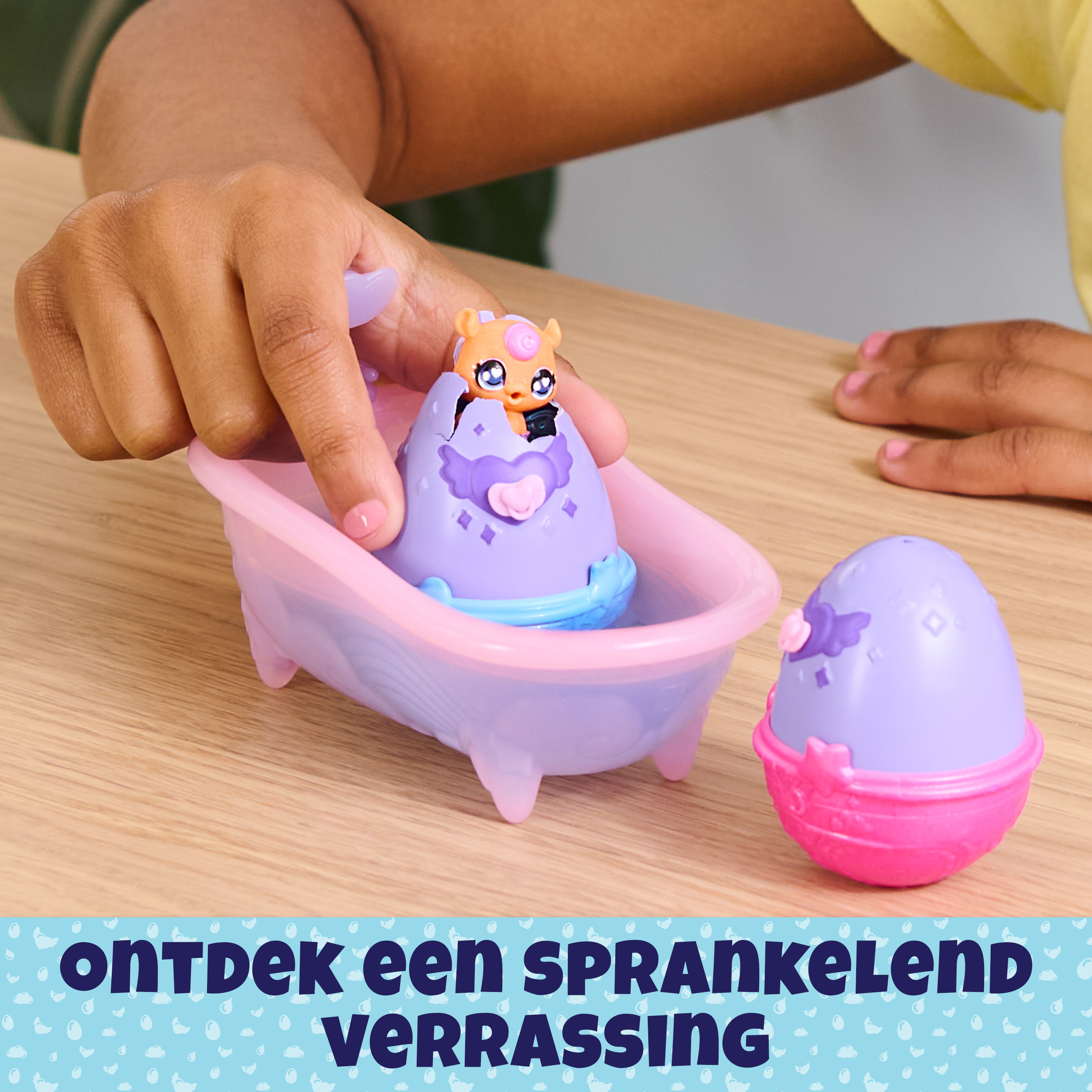 Die Hände eines Kindes interagieren mit einem Spielzeug mit einem Ei und einer Badewanne.