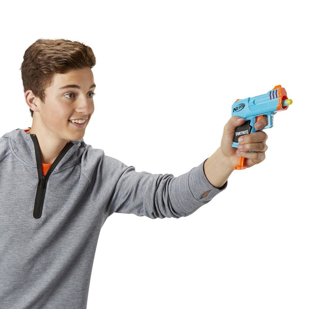 Ein Junge hält eine blaue Nerf Fortnite-Pistole und lächelt. Er trägt einen grauen Kapuzenpullover.