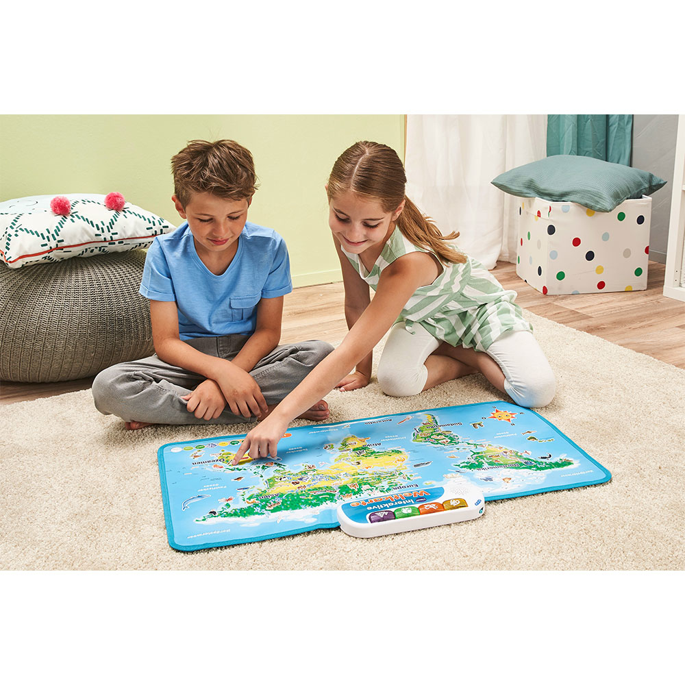 Zwei Kinder spielen mit einer Weltkarte auf einer blauen Matte, weißer Hintergrund.