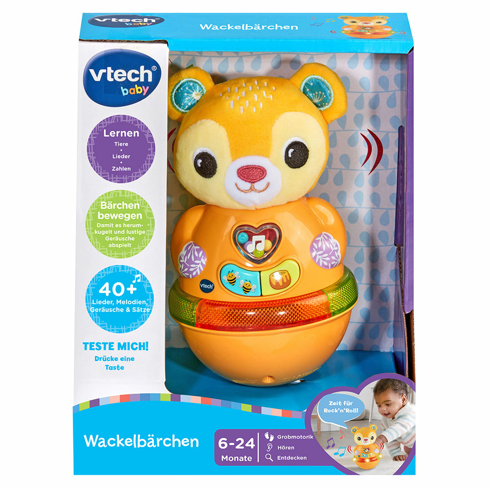 Ein gelbes Bärspielzeug auf einer Box. Die Box enthält Text und Bilder zu den Funktionen des Spielzeugs.