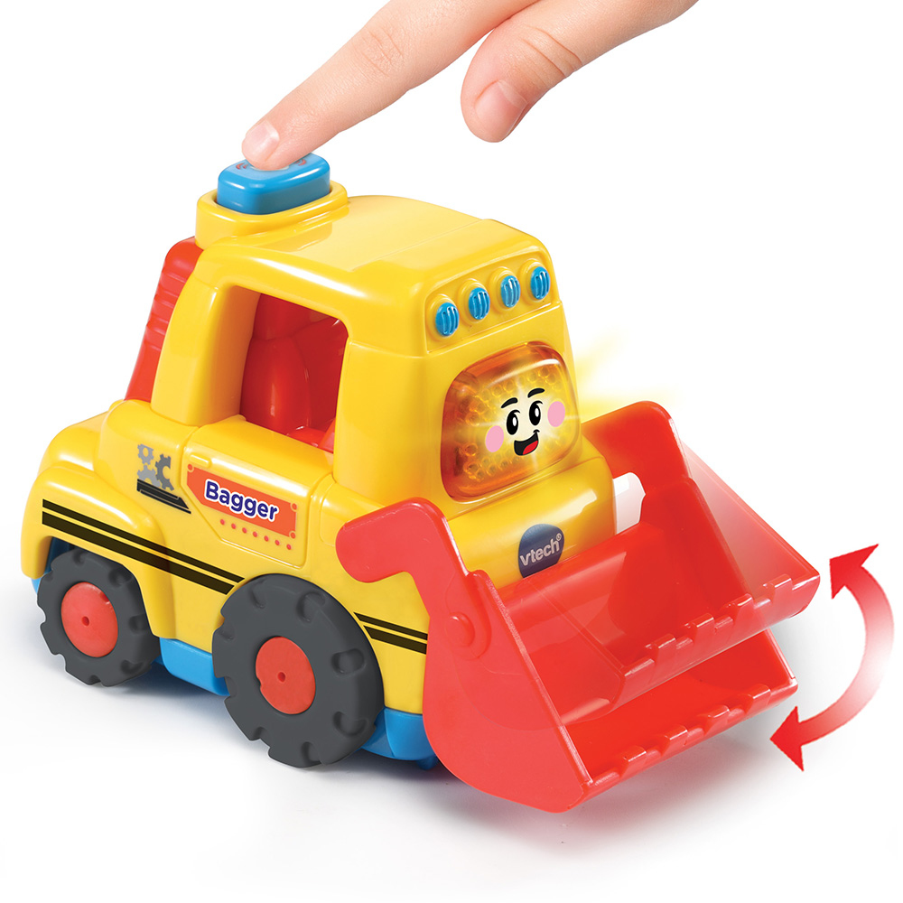 Ein gelber Spielzeugbagger mit einem lächelnden Gesicht wird gezeigt. Ein Finger drückt einen blauen Knopf oben, und die Schaufel ist rot.