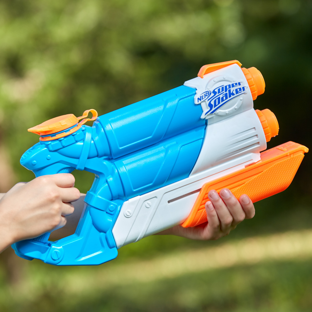 Pistola de agua Nerf Super Soaker azul y blanca. Sostenida por manos, fondo verde borroso.