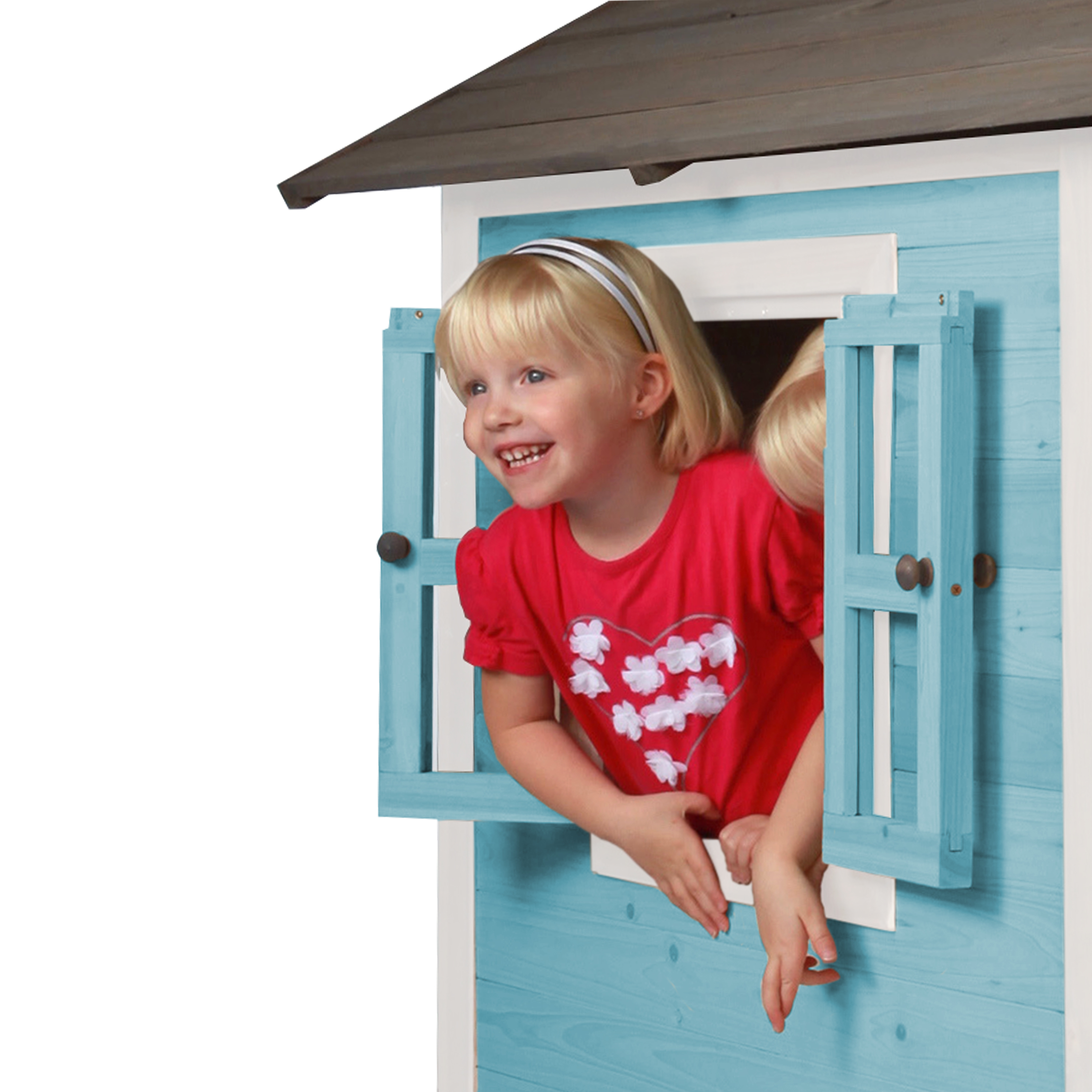 Junges Mädchen lächelt, blickt aus einem blauen Spielhausfenster, trägt ein rotes Hemd.